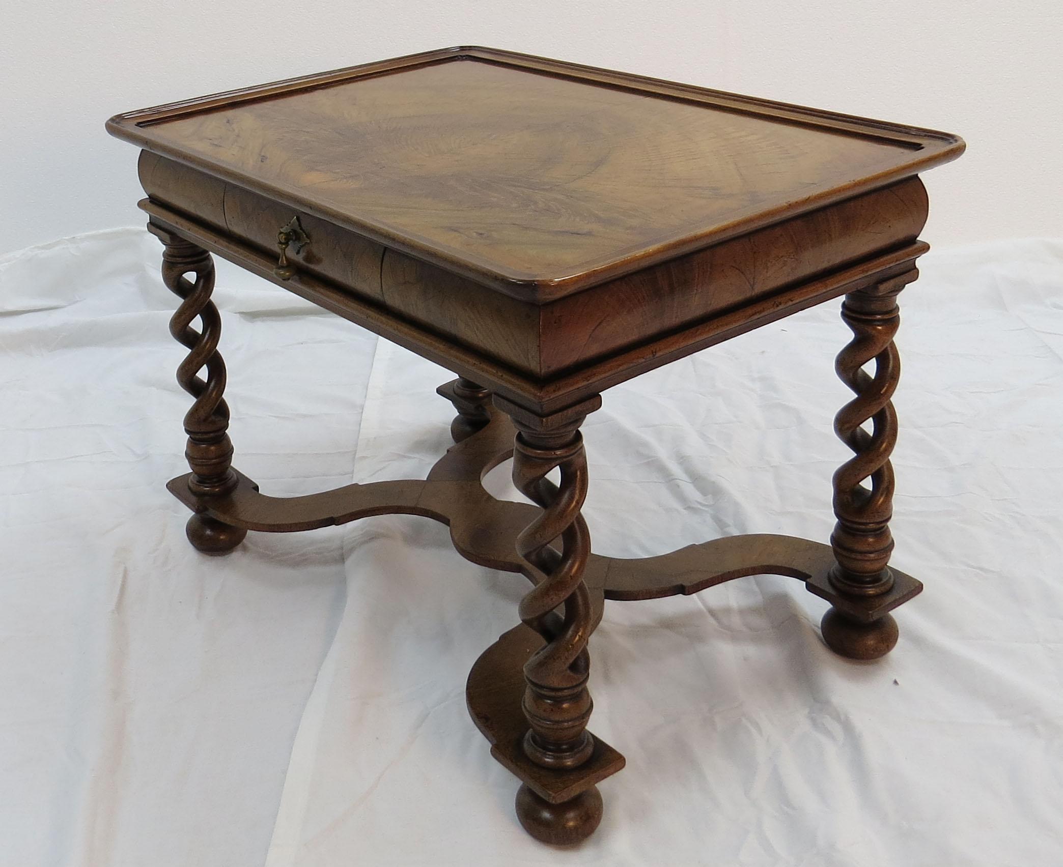 This quaint piece is a vintage small coffee table that was made in England sometime around the year 1940. The wood used is a lovely walnut which exhibits a vibrant grain and color. A small lip around the perimeter of the top prevents things from