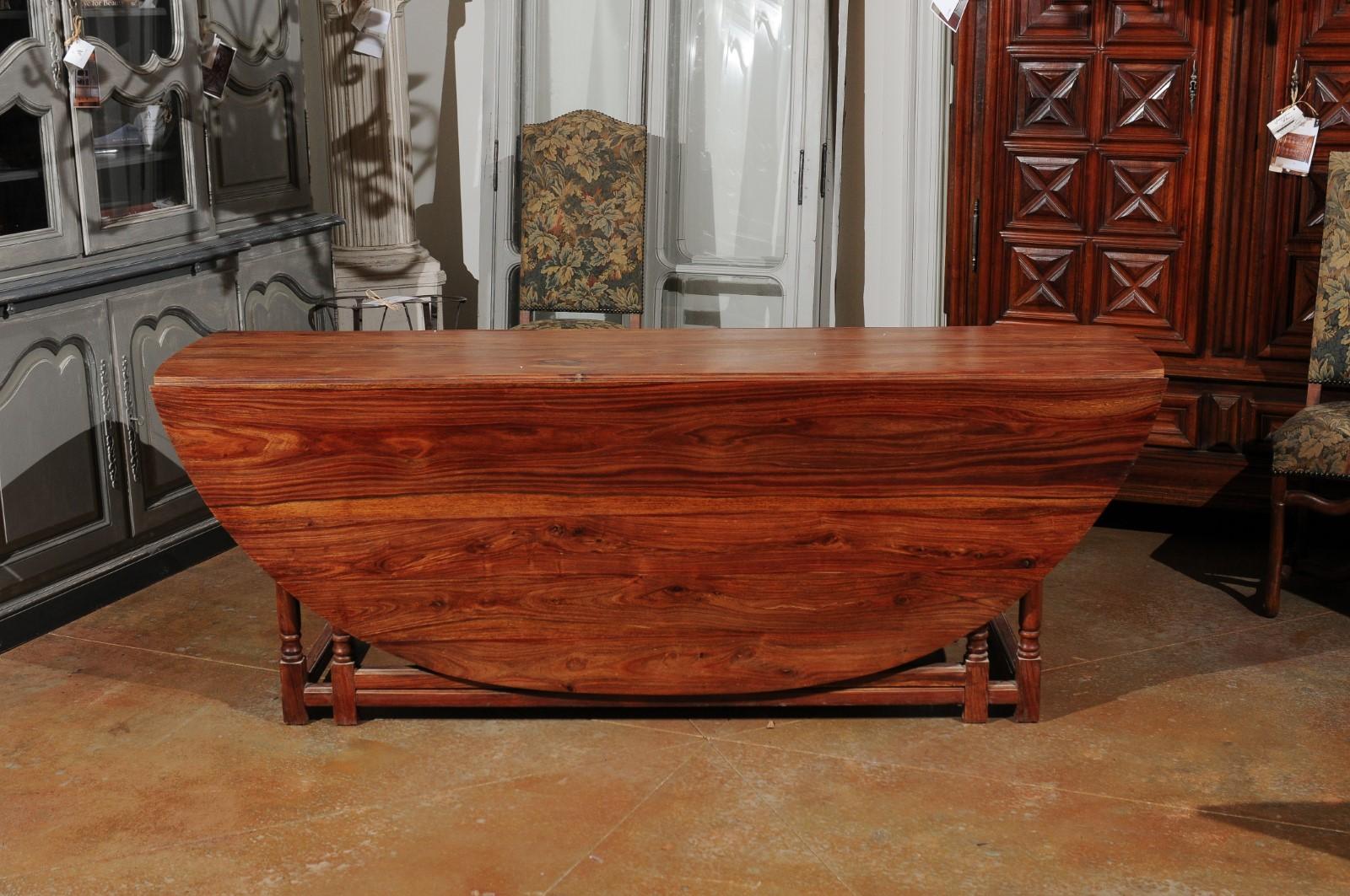 20ième siècle Table à pieds en forme de porte-à-faux en noyer anglais à plateau ovale et accoudoirs tournés avec pieds et traverses en vente
