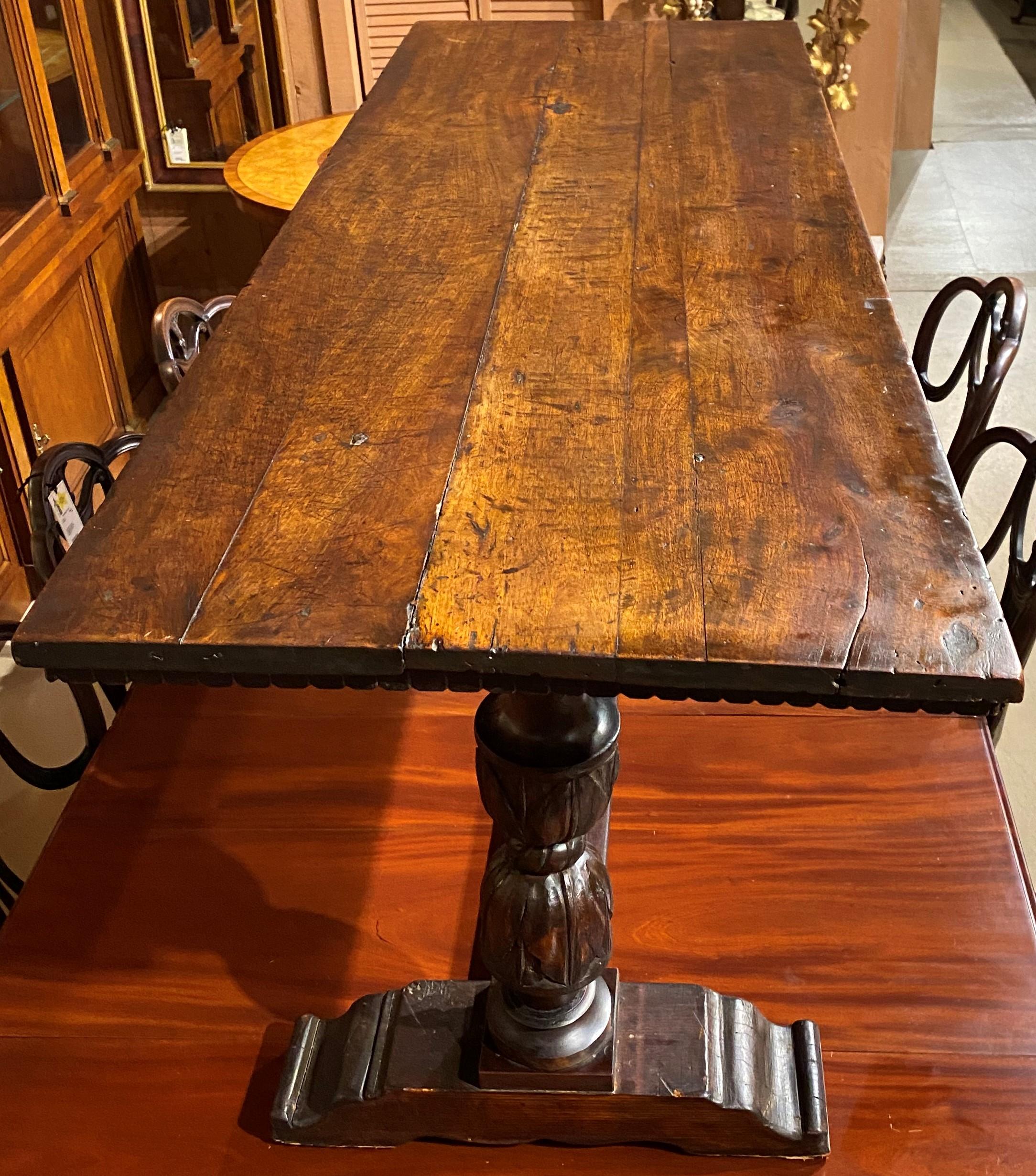 A fine English rectangular walnut refectory table made from 18th and 19th century components, including a molded carved edge top, a double pedestal carved base, supported with shoe feet and central single base stretcher. The table is in very good