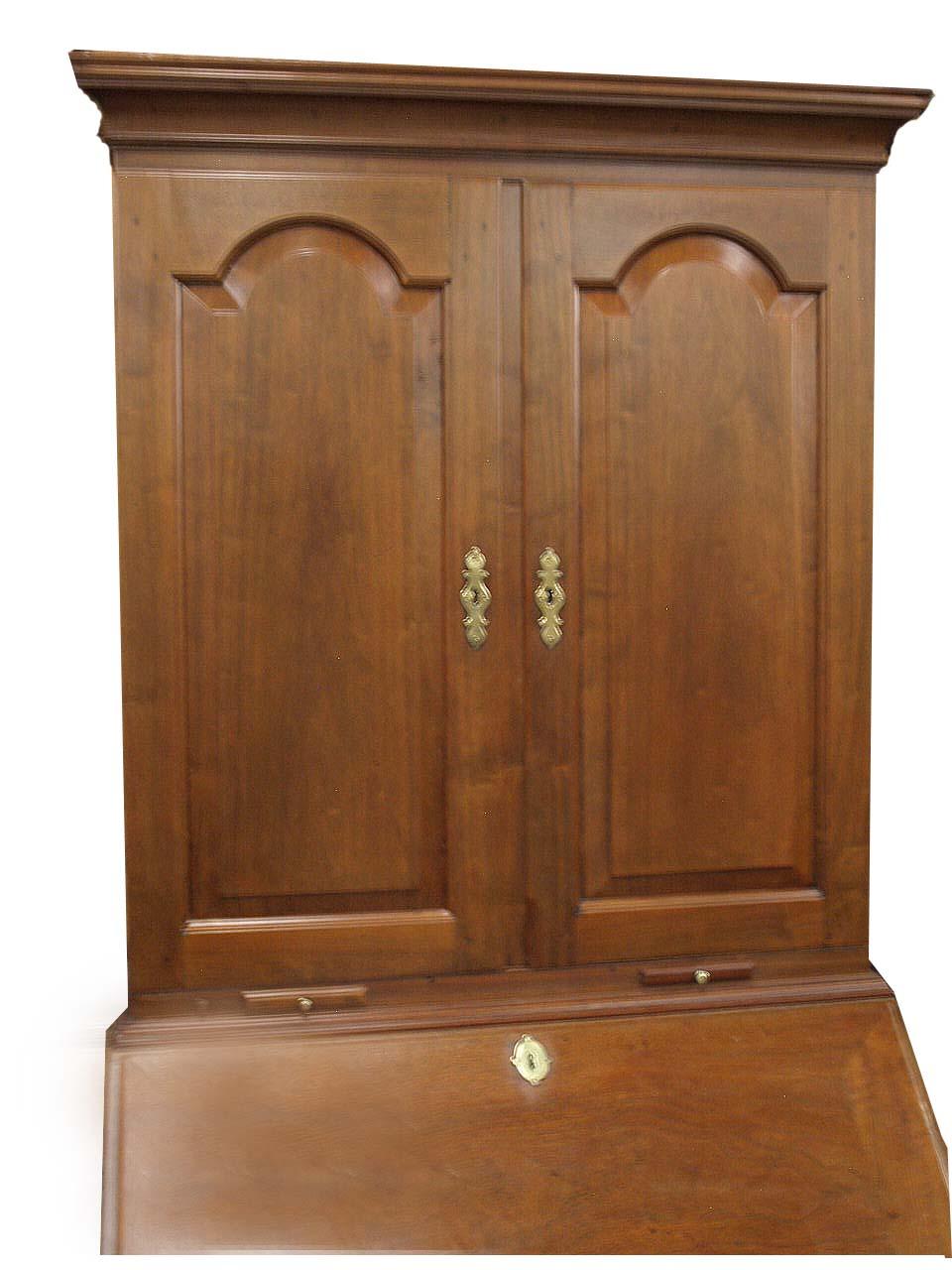 English walnut secretary, the top with cove cornice above double ''tombstone''raised panel doors and pull out candle slides; the fitted interior with adjustable shelves, cubby holes and three drawers; the desk with beautiful figured walnut fall