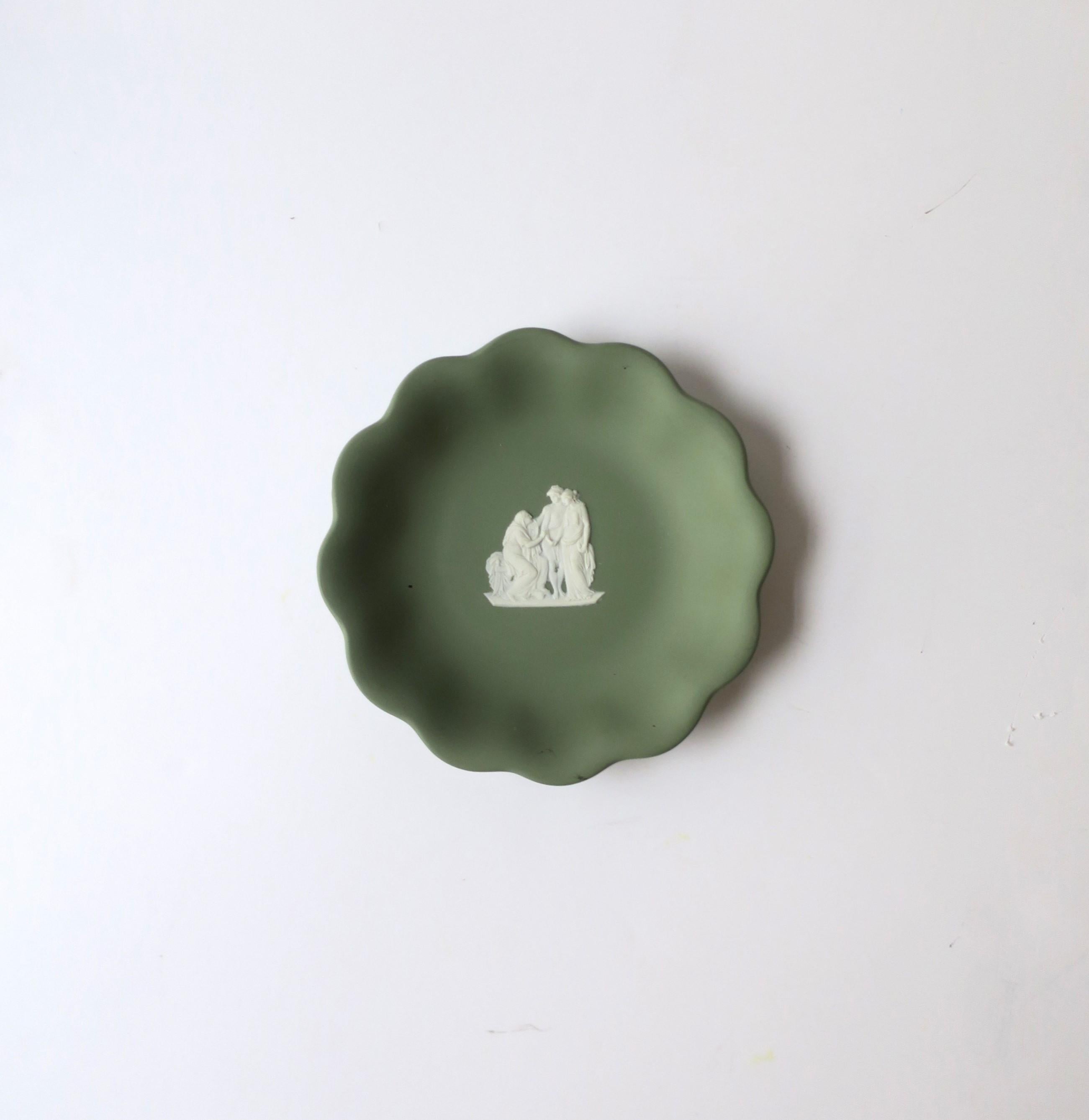 A beautiful English Wedgwood Jasperware sage green and white matte stoneware dish in the Neoclassical design style, mid-20th century, 1962, England. Piece is a matte stoneware in a light sage green with a scalloped edge and a white neoclassical