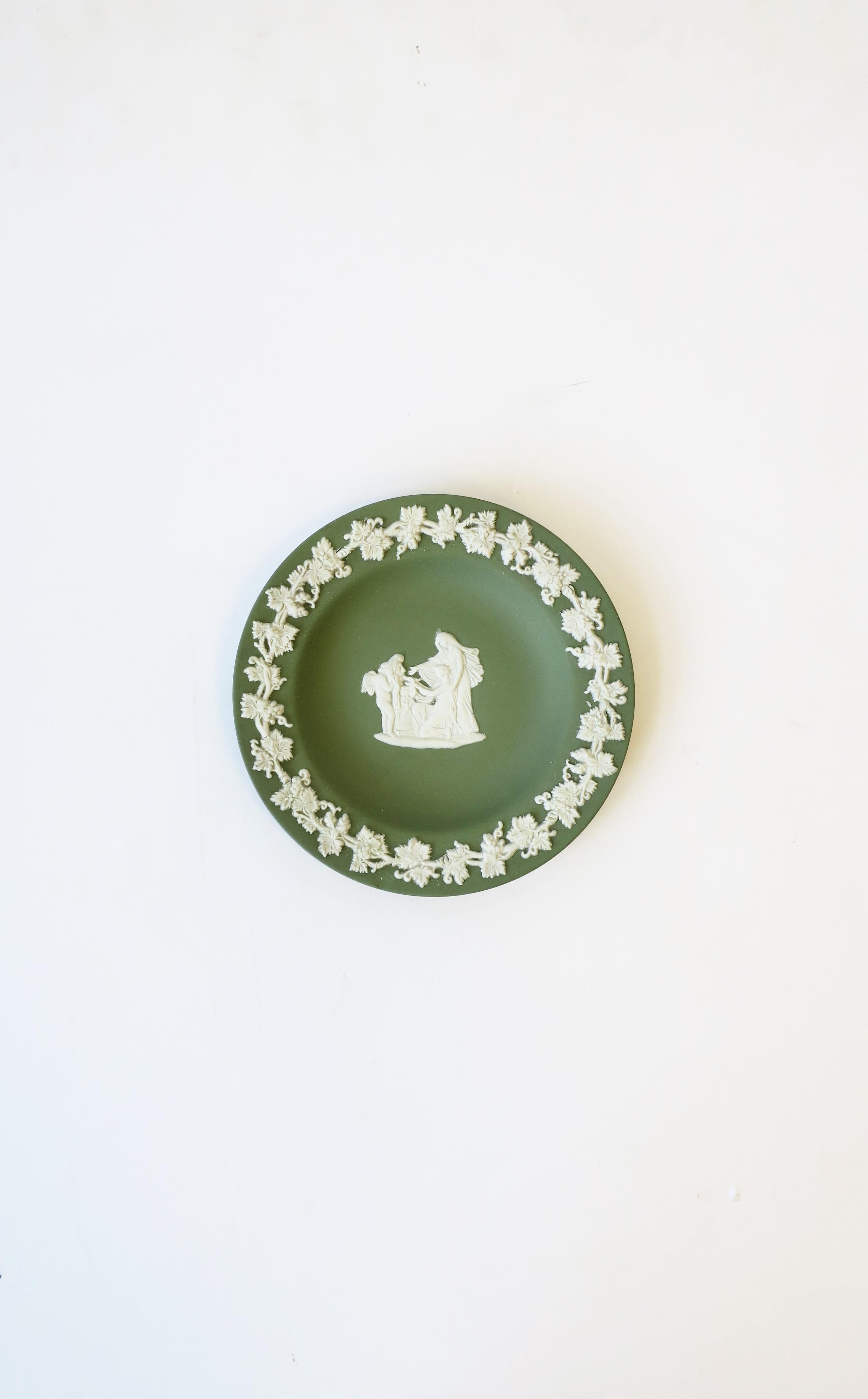 A beautiful English Wedgwood Jasperware sage green and white round jewelry dish with neoclassical design, circa 20th century, 1979, England. Piece is a matte stoneware in a light green with a white neoclassical raised relief at center and leaf