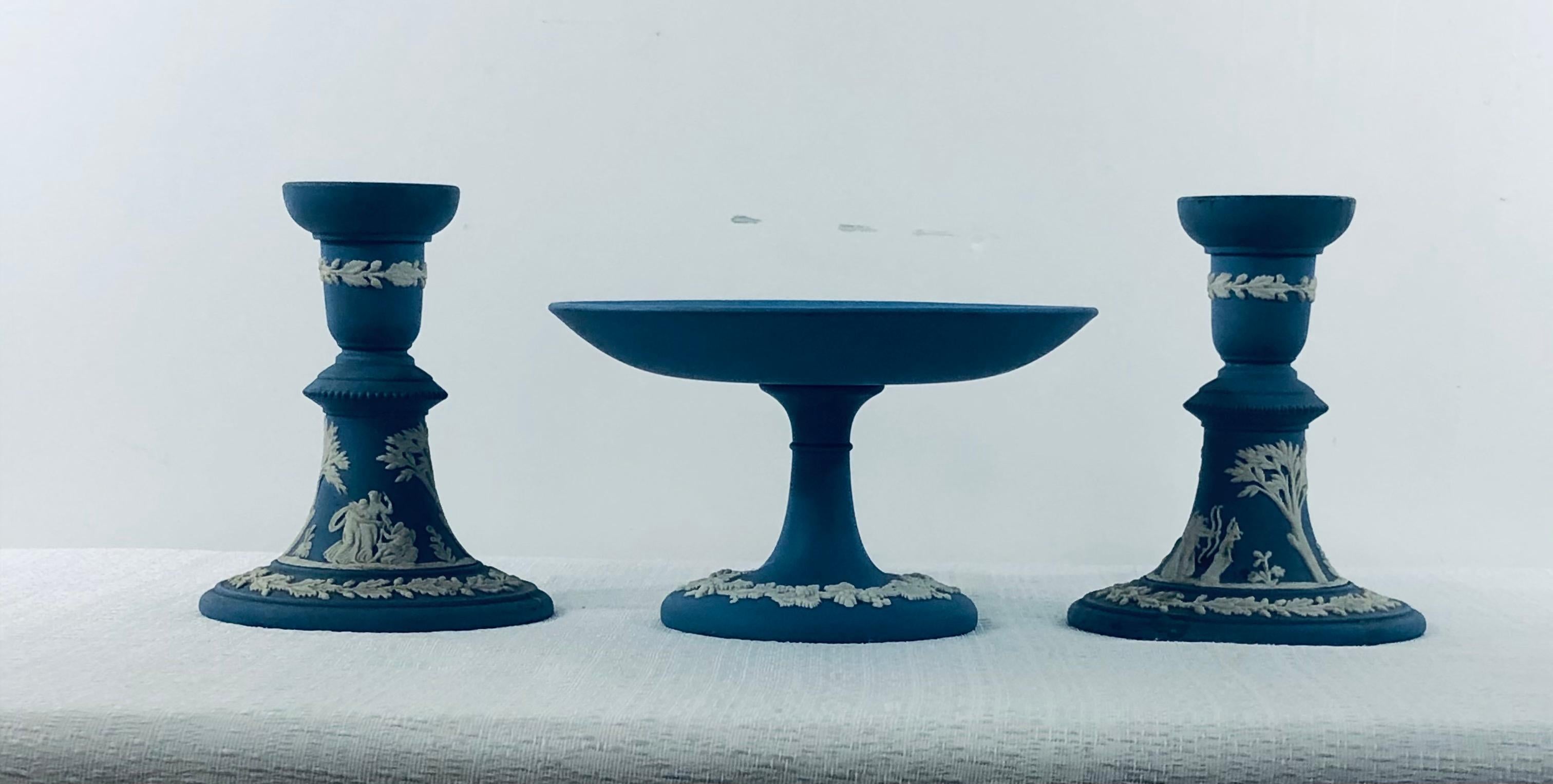 A pair of English Wedgwood Jasperware candleholders in “Wedgwood Blue” and decorative serving plate. Perfect to decorate your dining table in style. Each piece features a white design depicting high relief acanthus leaves and white sprigged