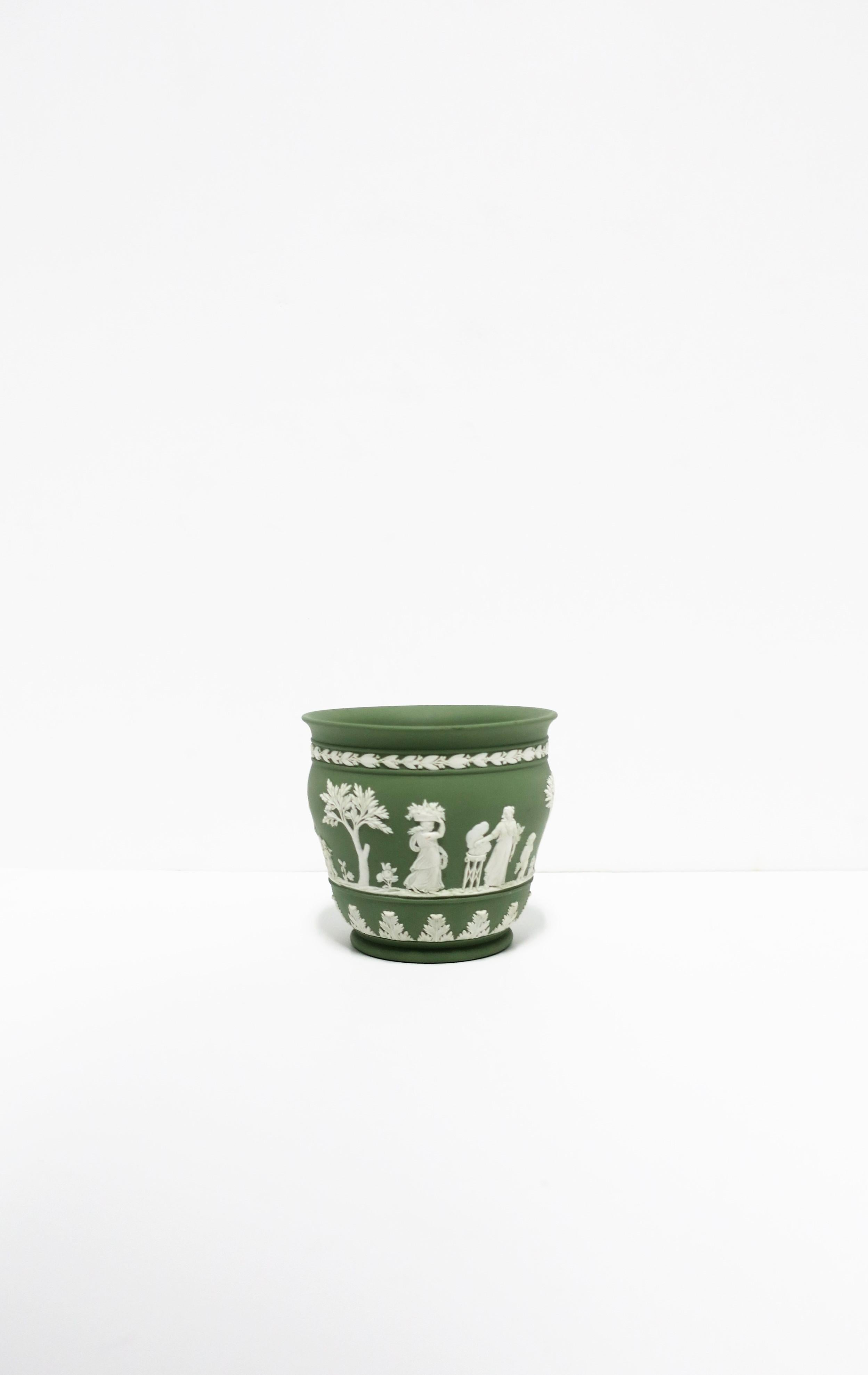 A beautiful English Wedgwood sage green and white matte Jasperware stoneware planter cachepot jardinière (plant pot holder) in the neoclassical design style, circa 20th century, England. Piece is a matte stoneware in a light green with a white