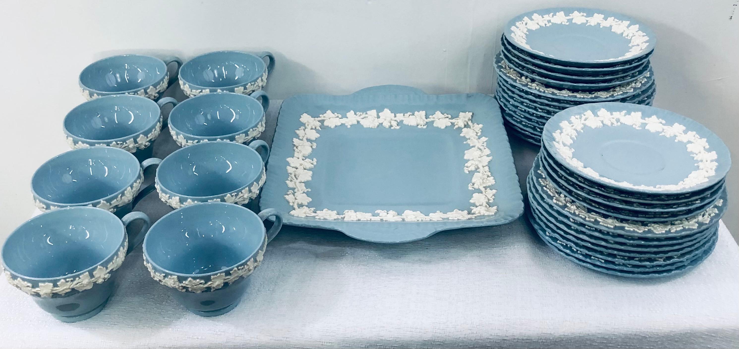 A large set of 33 pieces of the beautiful English Wedgwood Jasperware in Wedgwood blue. Each piece features a white design depicting white sprigged reliefs of Acanthus leaves and flowers. The set contains 8 coffee or tea cups, 8 saucers plates, 16