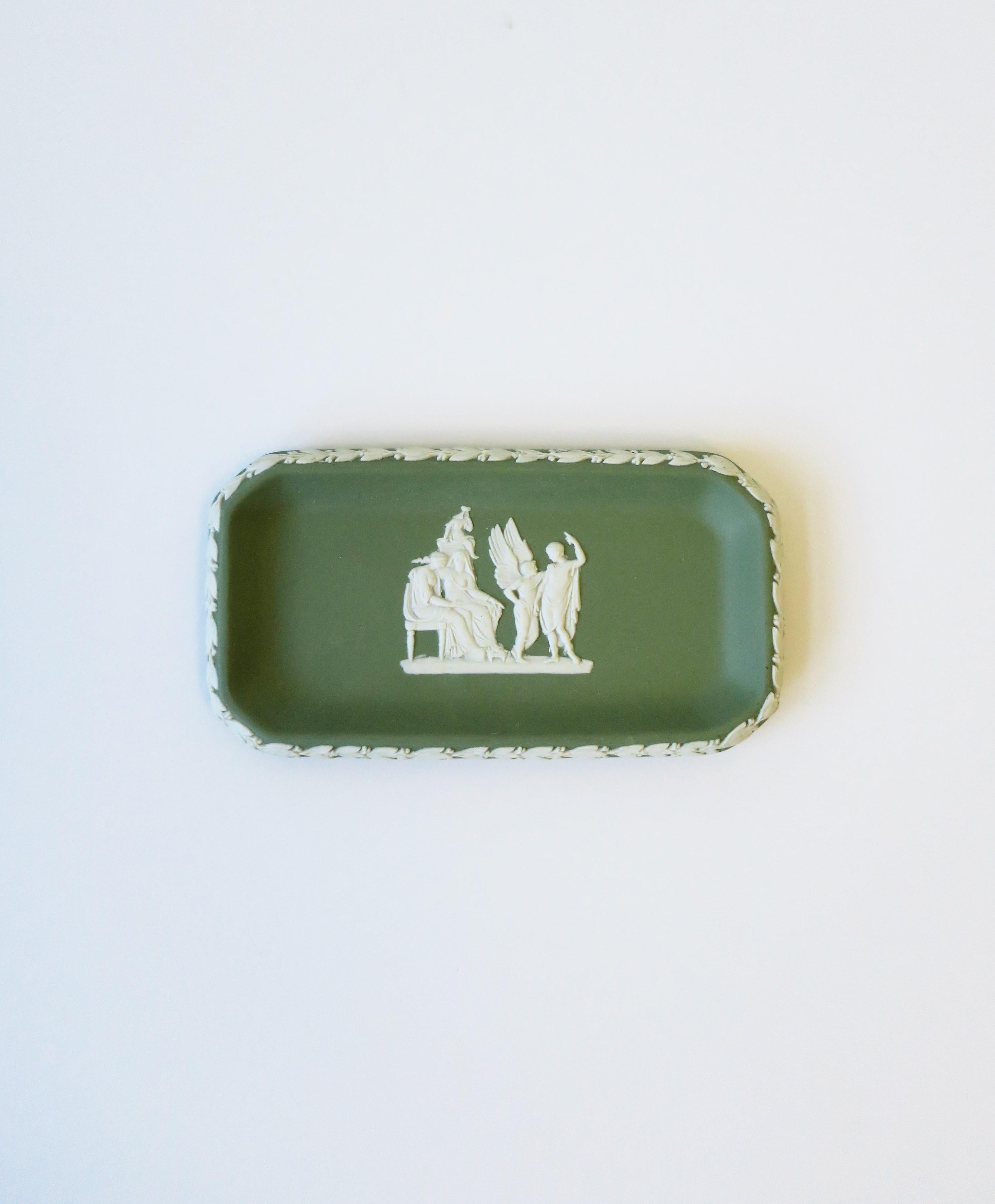 A beautiful English Wedgwood Jasperware small rectangular jewelry dish with Neoclassical design, 1961, England. Piece is a matte stoneware in a light green with a white Neoclassical raised relief at center and leaf design around edge. Great as a