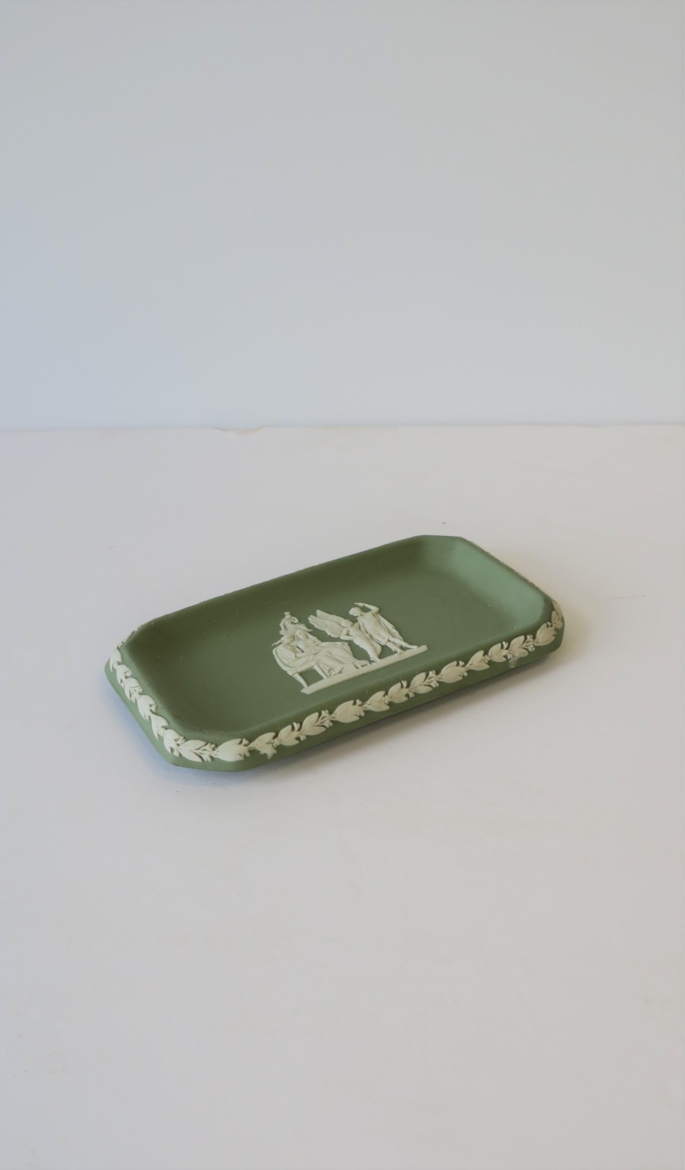 A beautiful English Wedgwood Jasperware small rectangular jewelry dish with a neoclassical design, circa 20th century, England. Piece is a matte stoneware in a light green with a white neoclassical raised relief at center and leaf design around