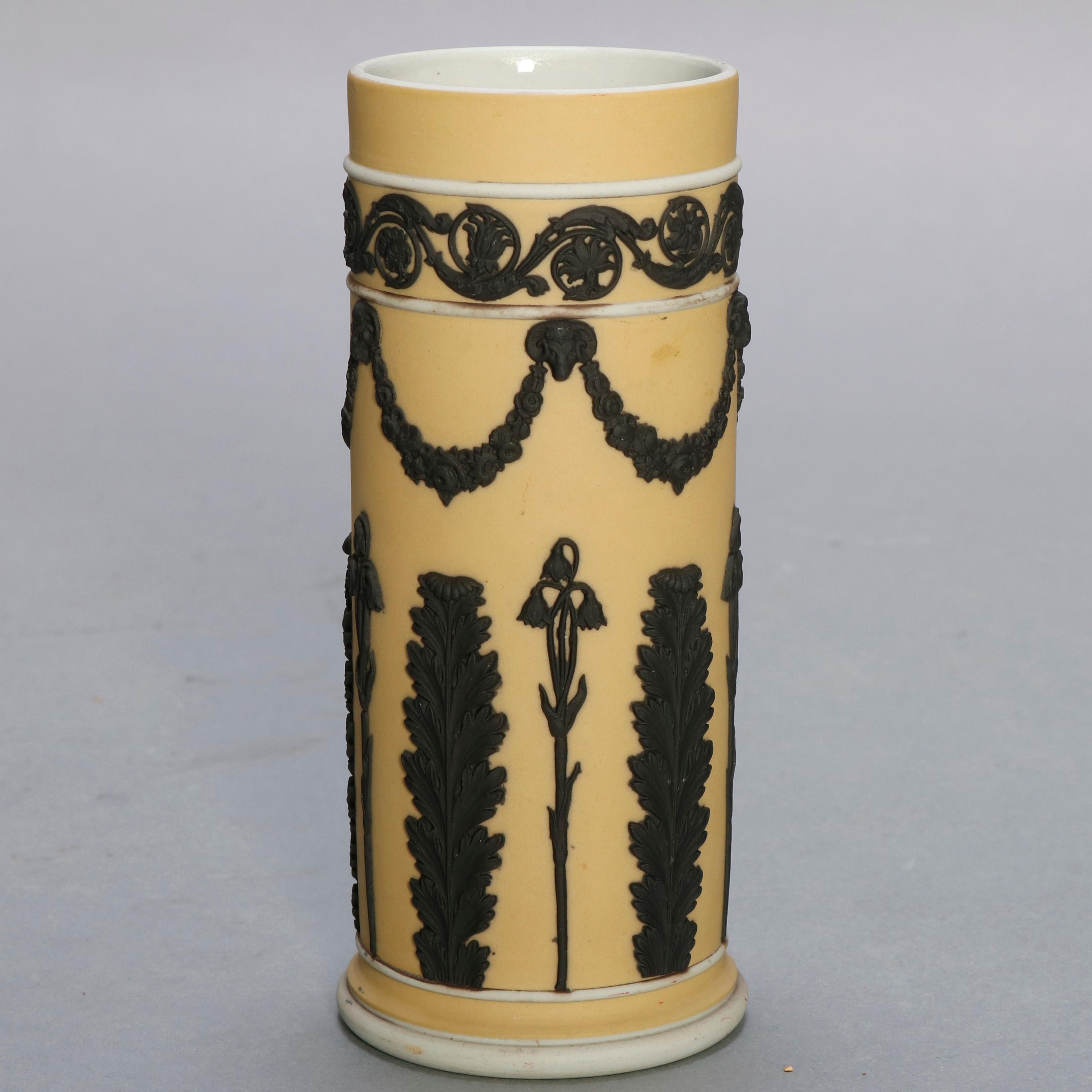 A pair of English Classical spill vases by Wedgwood offer bisque porcelain with yellow dip finish and black basalt bas relief repeating acanthus, foliate swag and scrollwork band, stamped on base as photographed, circa 1930

Measures: 6.5