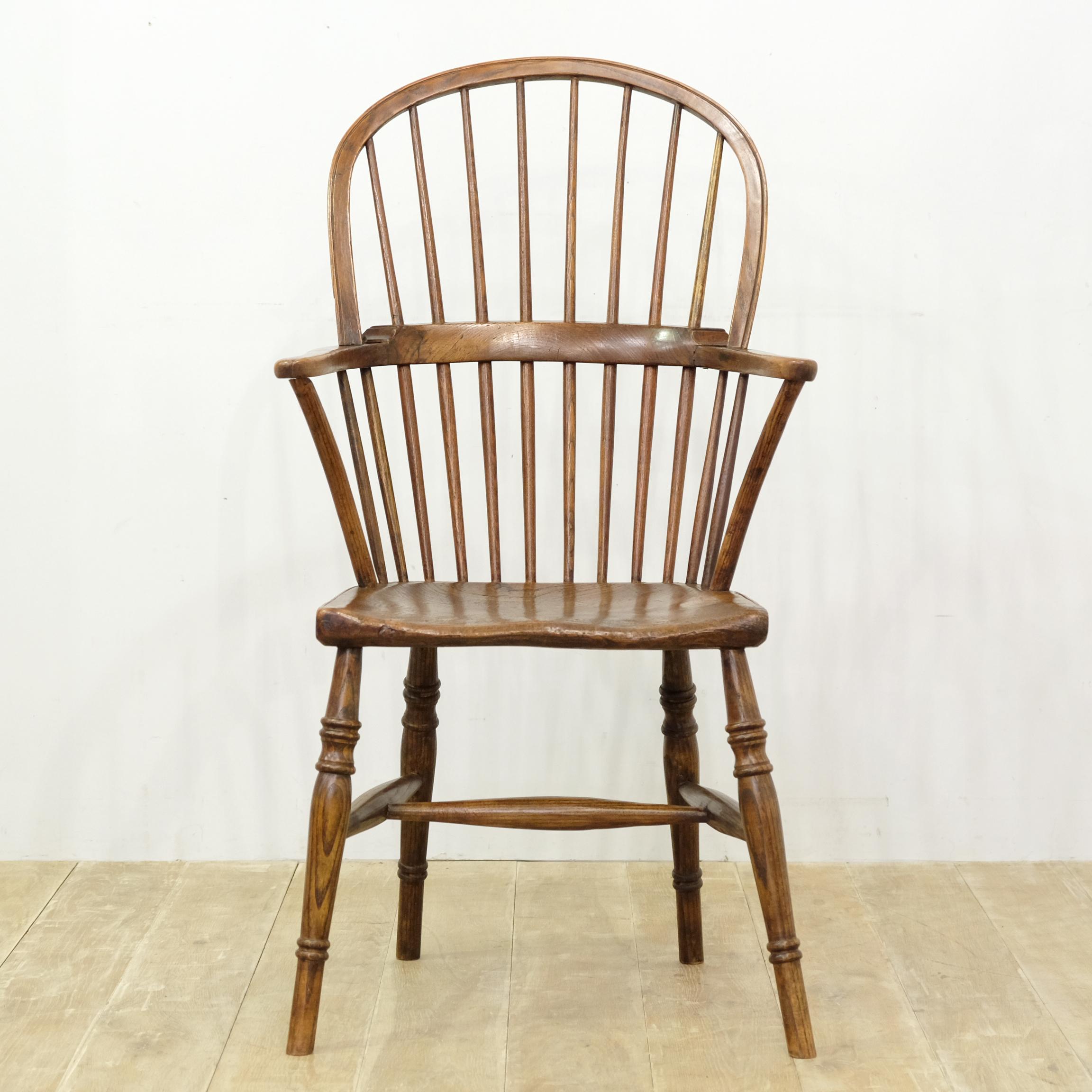 Characterful Georgian ash and elm Windsor chair. Flat-fronted elm seat with interesting grain pattern and tactile feel. Decoratively turned legs united by tapering H stretcher. Crook-shaped arm supports with typical three-part arm. Lovely rich