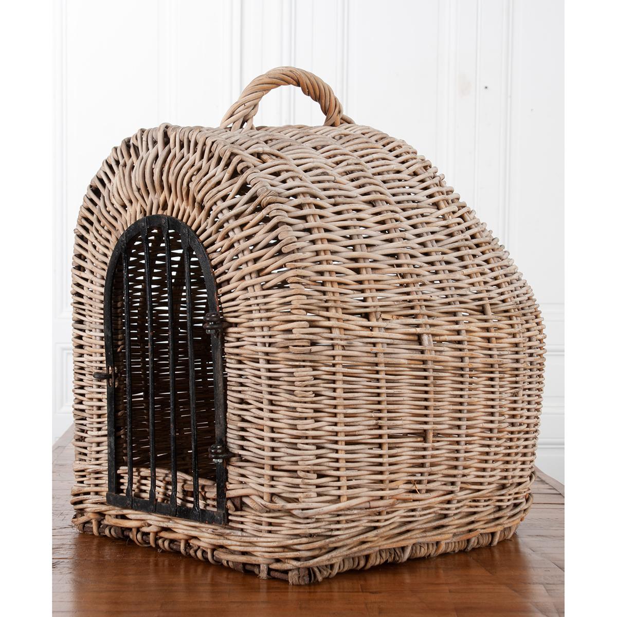This is a unique hand-woven wicker animal carrier that can be used to tote your beloved pet or as perfectly rustic decor. The beautifully light-colored wicker is strong and fitted with the original metal gate and a tightly woven handle for easy