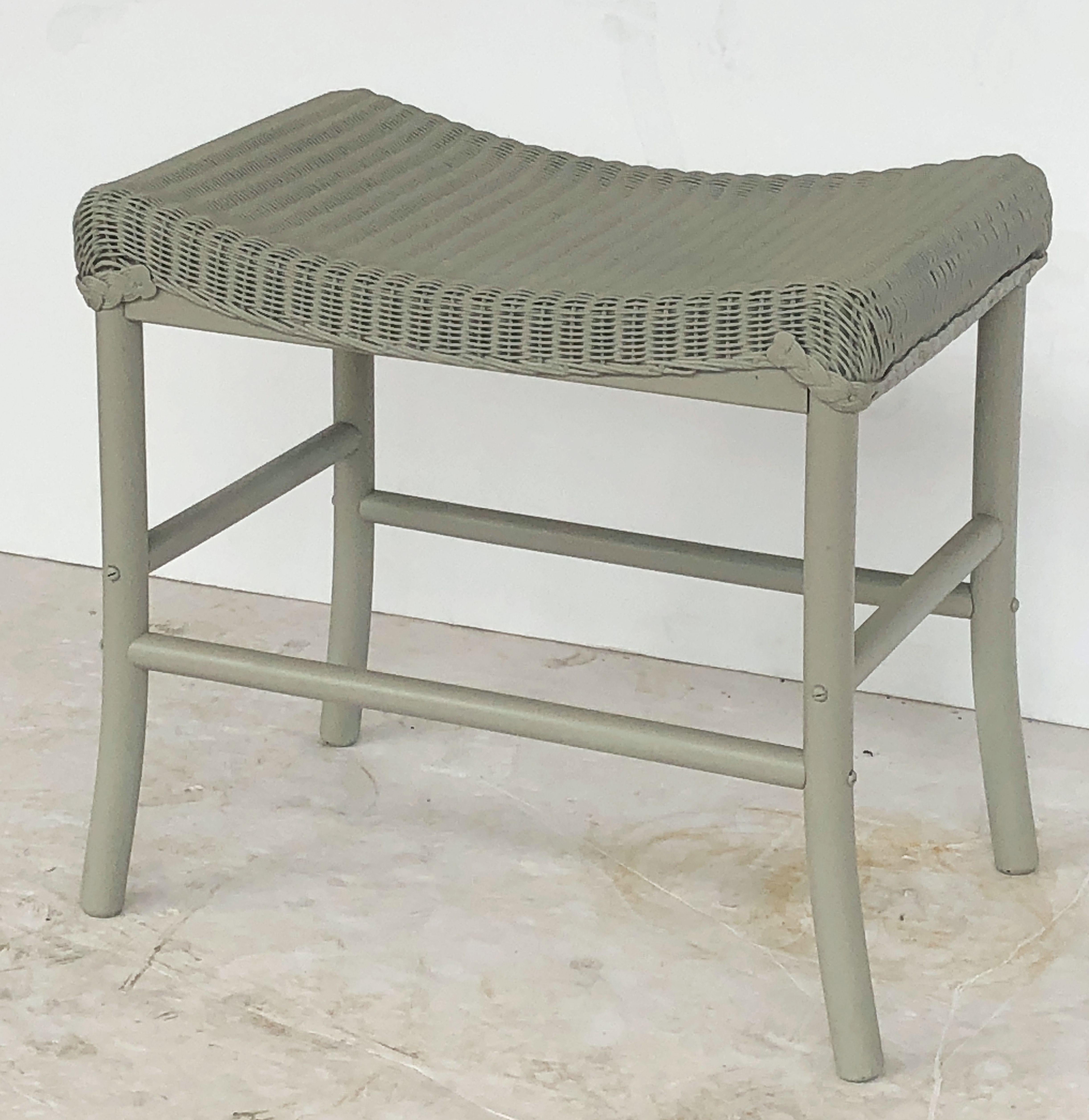A fine Lloyd Loom stool or ottoman, synonymous with classic English style, featuring a rectangular seat of woven wicker and wire over a wood frame stretcher.

Perfect for an indoor or outdoor garden room, garden, or conservatory, this stool or