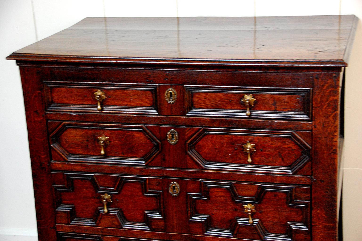 English William and Mary period oak paneled chest of four drawers. Each one of the graduated drawers has a different pattern of molding on the drawer front, a detail which was used for the more expensive chests of the late 17th century, as it took