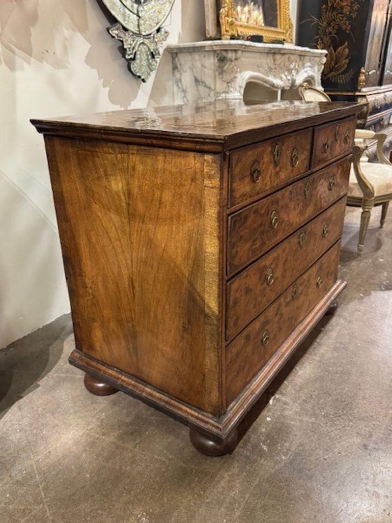 18th century English William and Mary walnut chest on bun feet. You're exploring a piece steeped in 17th-century elegance—English William and Mary walnut chests are known for their geometric veneers, bun feet, and architectural presence. Circa 1800.