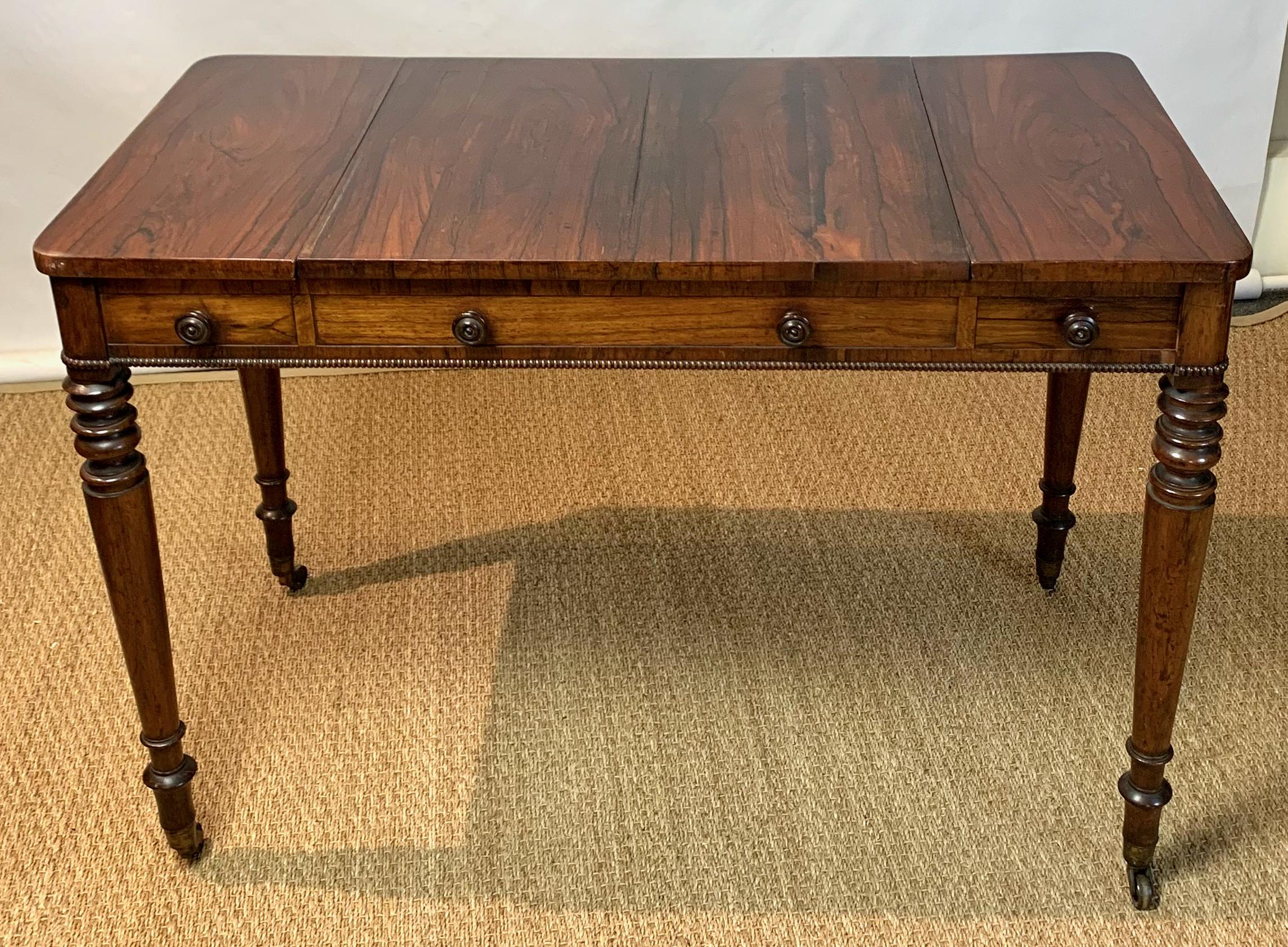 An elegant William IV or late Regency rosewood games or tric-trac table. The fitted rosewood top slides to reveal a chessboard on reverse and an inset backgammon board retaining its original velvet playing surface. Each side offers a small drawer.