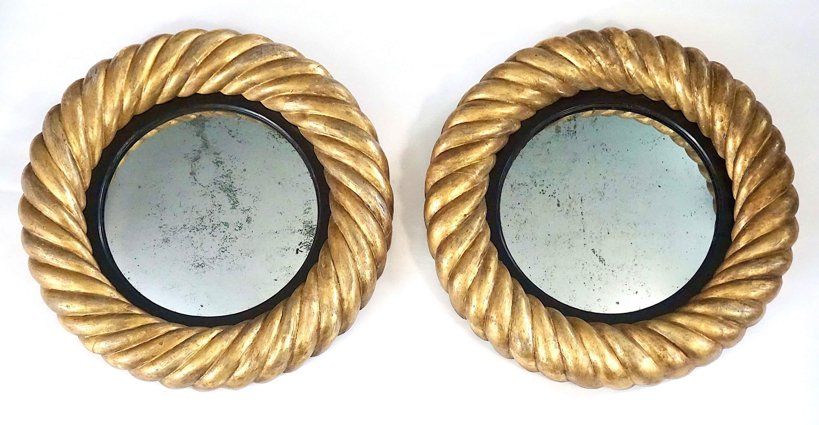 A rare and exceptional pair of circa 1830, English regency, late George IV, early William IV period convex mirrors having carved frames in original gilding of unusual thickly exaggerated 'gadrooned' design with ebonized smooth fillets and original