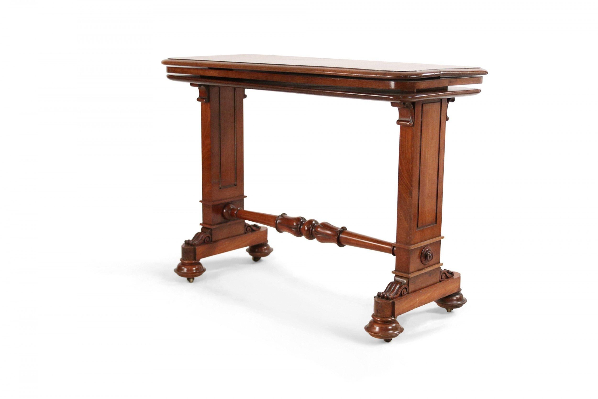 English William IV mahogany console table with rectangular top, rounded corners, and two carved legs connected by a turned, carved stretcher.