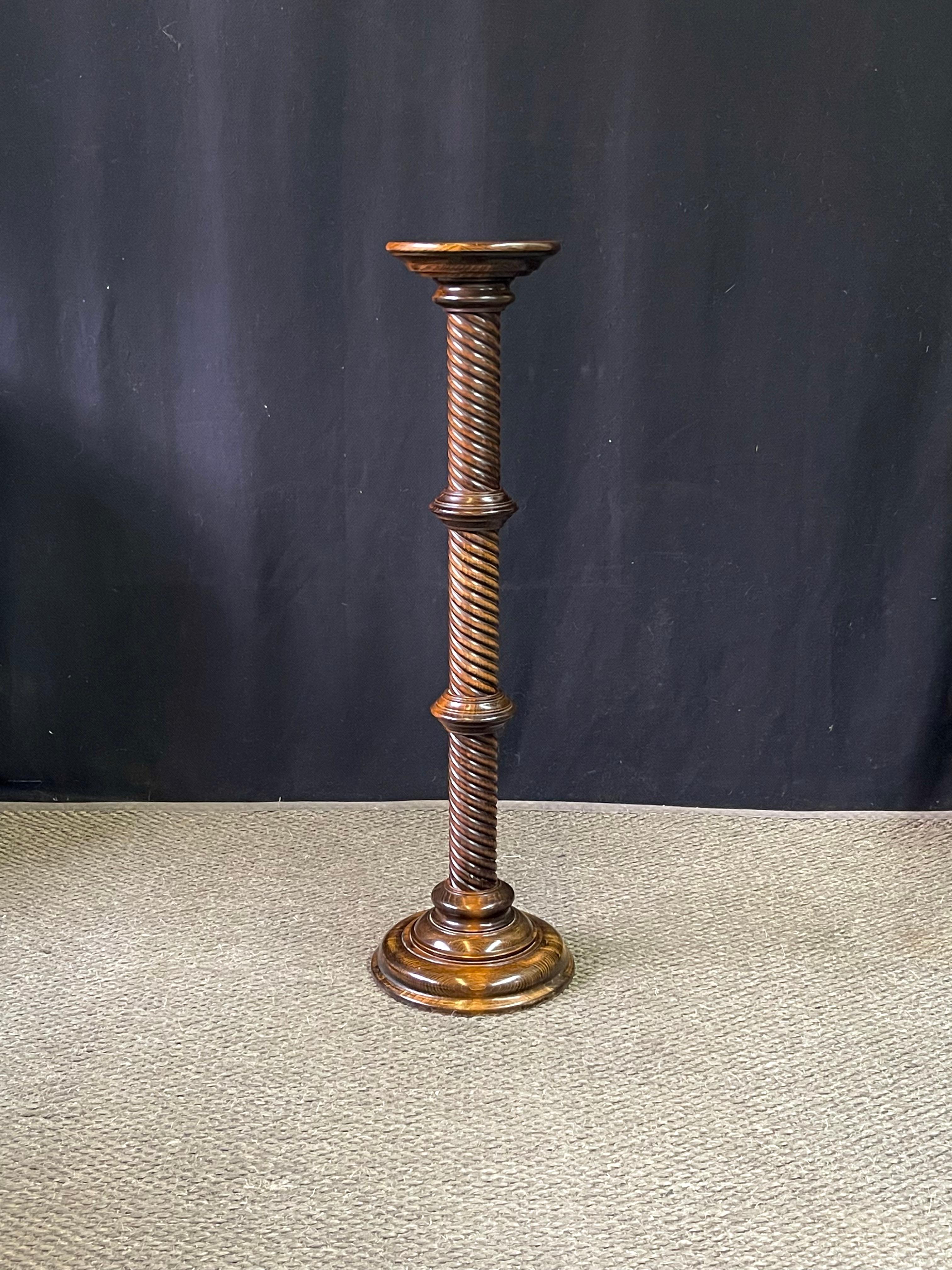 This is a charming 20th century English William IV revival plant stand or torchère of oak in the original finish. The plant stand features a dished top to securely rest a plant, candle, or a vase. The round top smoothly tapers to a handsome turned