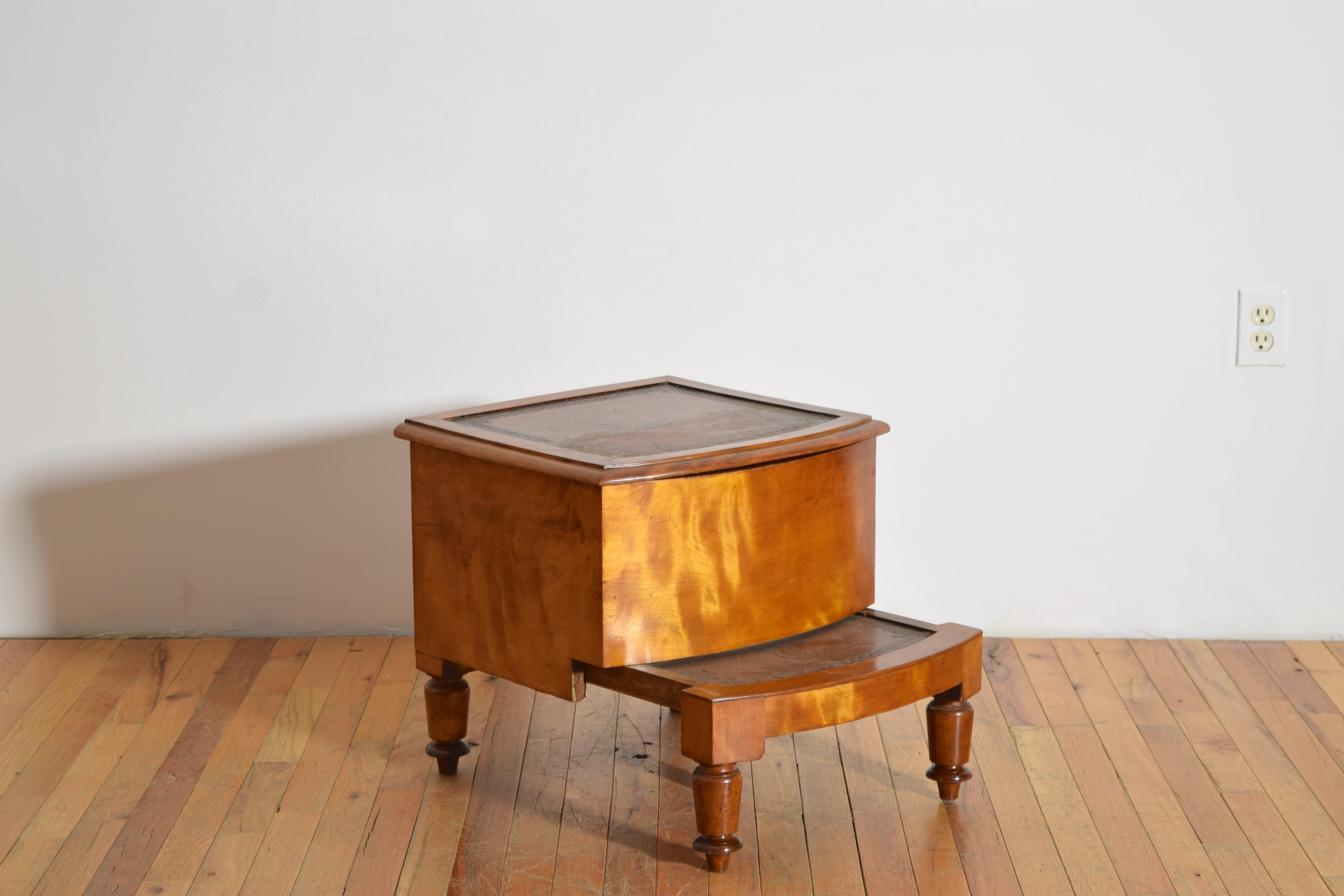 en forme de boîte rectangulaire reposant sur des pieds tournés, le dessus et le marchepied avec des insertions de cuir au pochoir, l'intérieur doublé de velours vert, profondeur avec le marchepied étendu 23.5 pouces