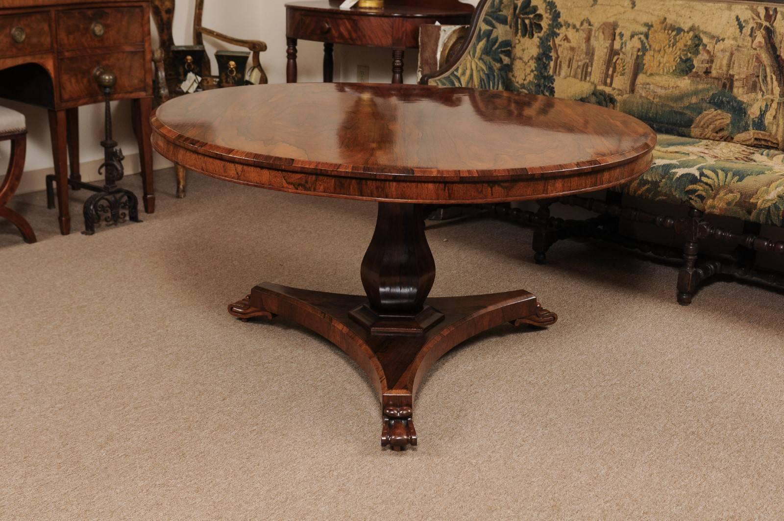 Rosewood center table with circular top with cross-banded canted boarder, pedestal base and scroll feet.


 