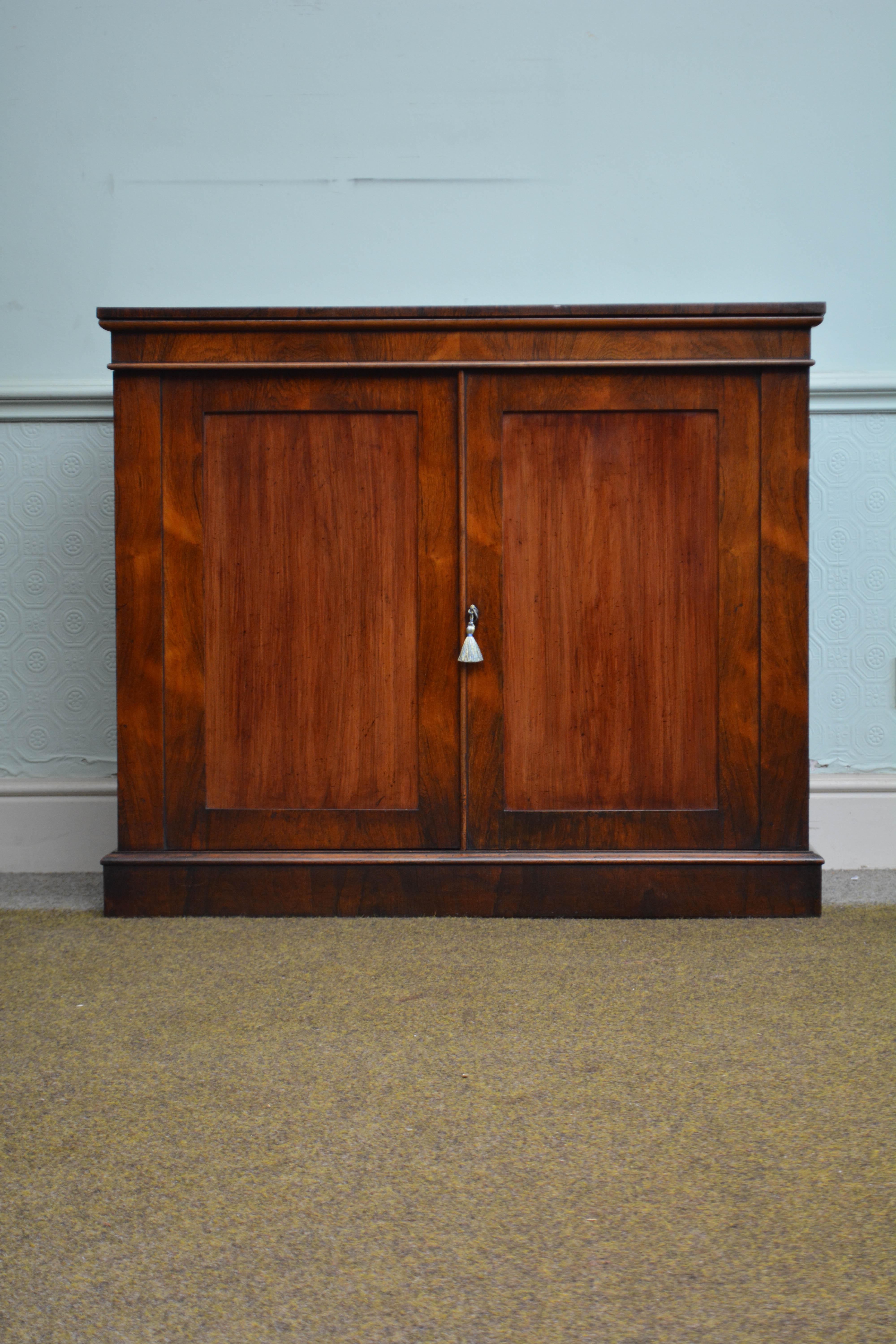 P0315 Fine quality and very elegant English William IV, two door rosewood chiffonier, having well figured oversailing top with moulded edge and a shallow frieze below, pair of cabinet doors with solid mahogany panels enclosing a removable shelf and