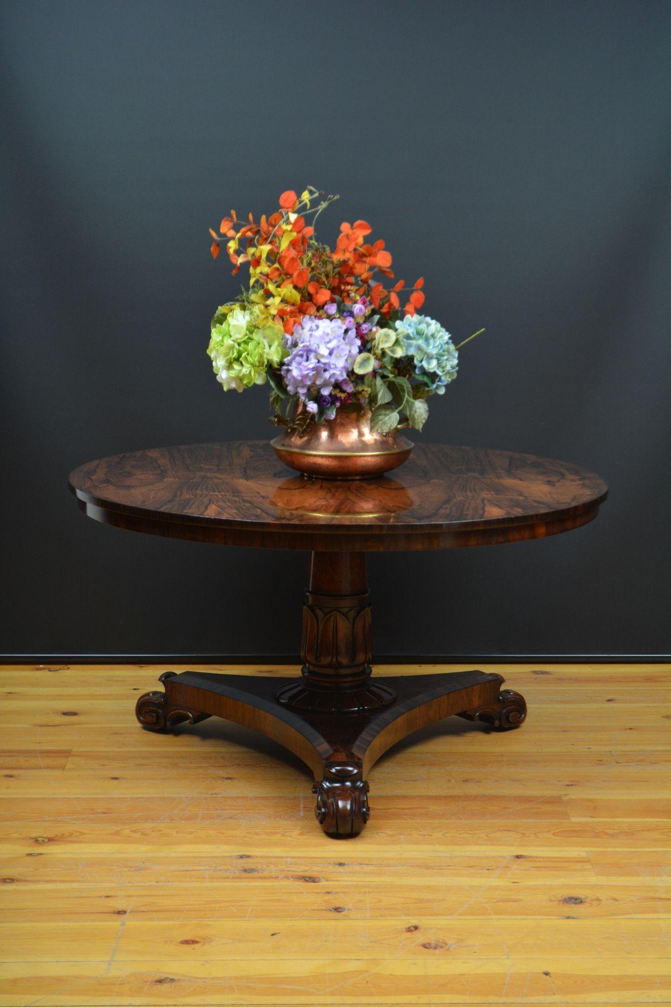 A010 Exceptionnelle table centrale circulaire William IV en bois de rose, avec un plateau basculant et un placage de livres assortis. Elle repose sur une colonne fuselée tournée, avec un chapiteau sculpté de tulipes se terminant par un collier