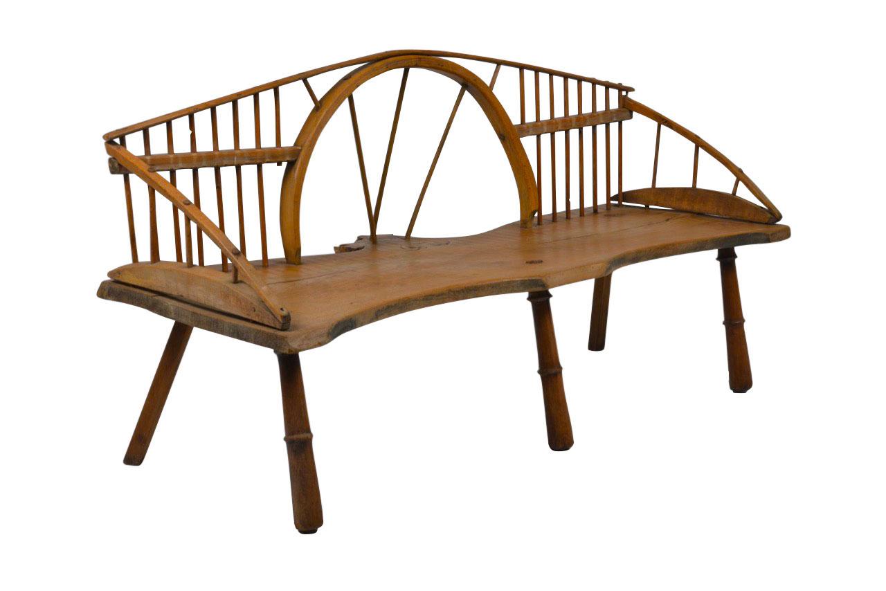 Quirky version of the Windsor style bench. A Windsor chair is a chair built with a solid wooden seat into which the chair-back and legs are round-tenoned, or pushed into drilled holes, in contrast to standard chairs, where the back legs and the