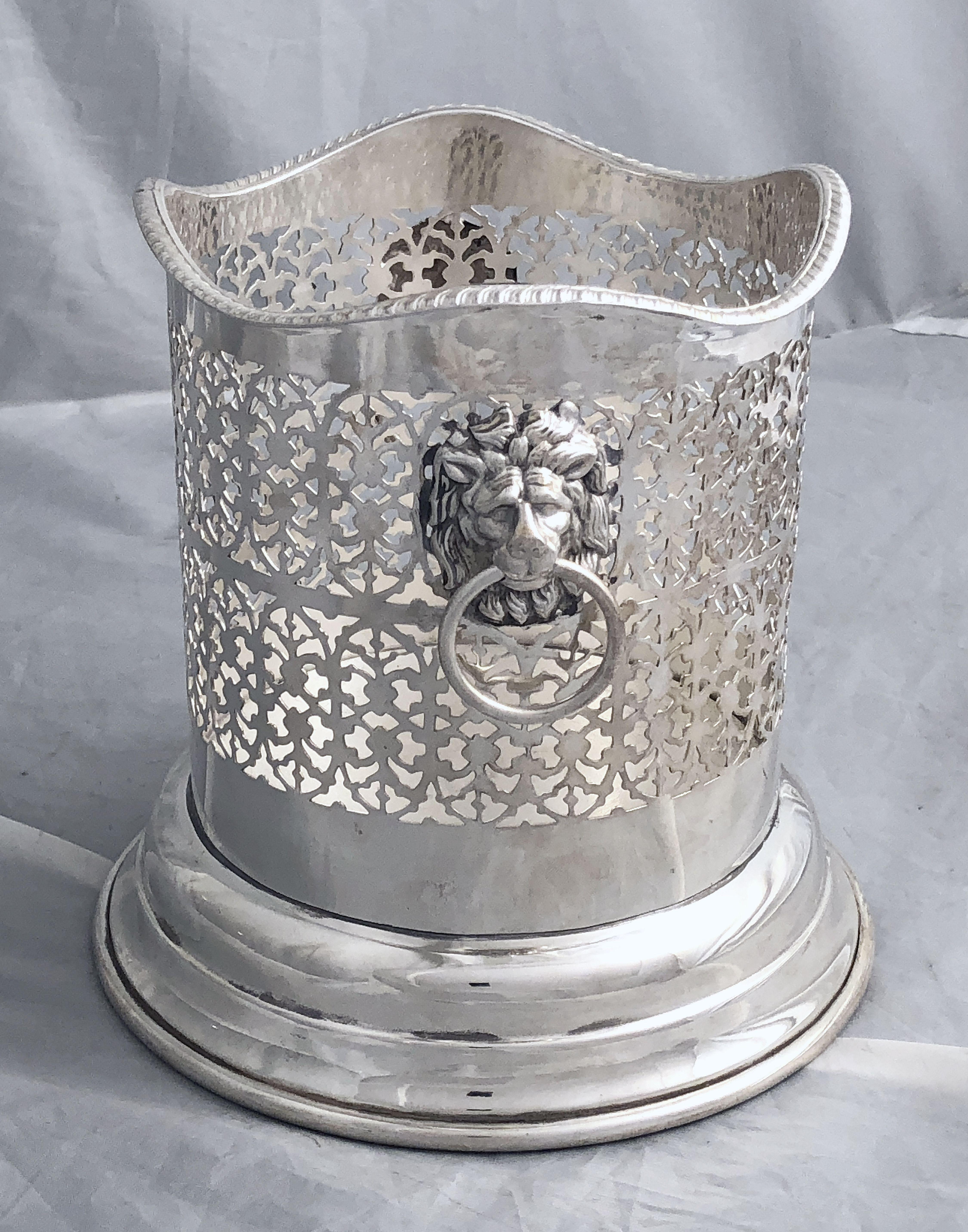 A handsome English wine bottle display holder or coaster of fine plate silver, featuring a pierced design around the circumference and opposing Regency lion ring pull handles, with serpentine edge around the top.

Designed to add a fine level of