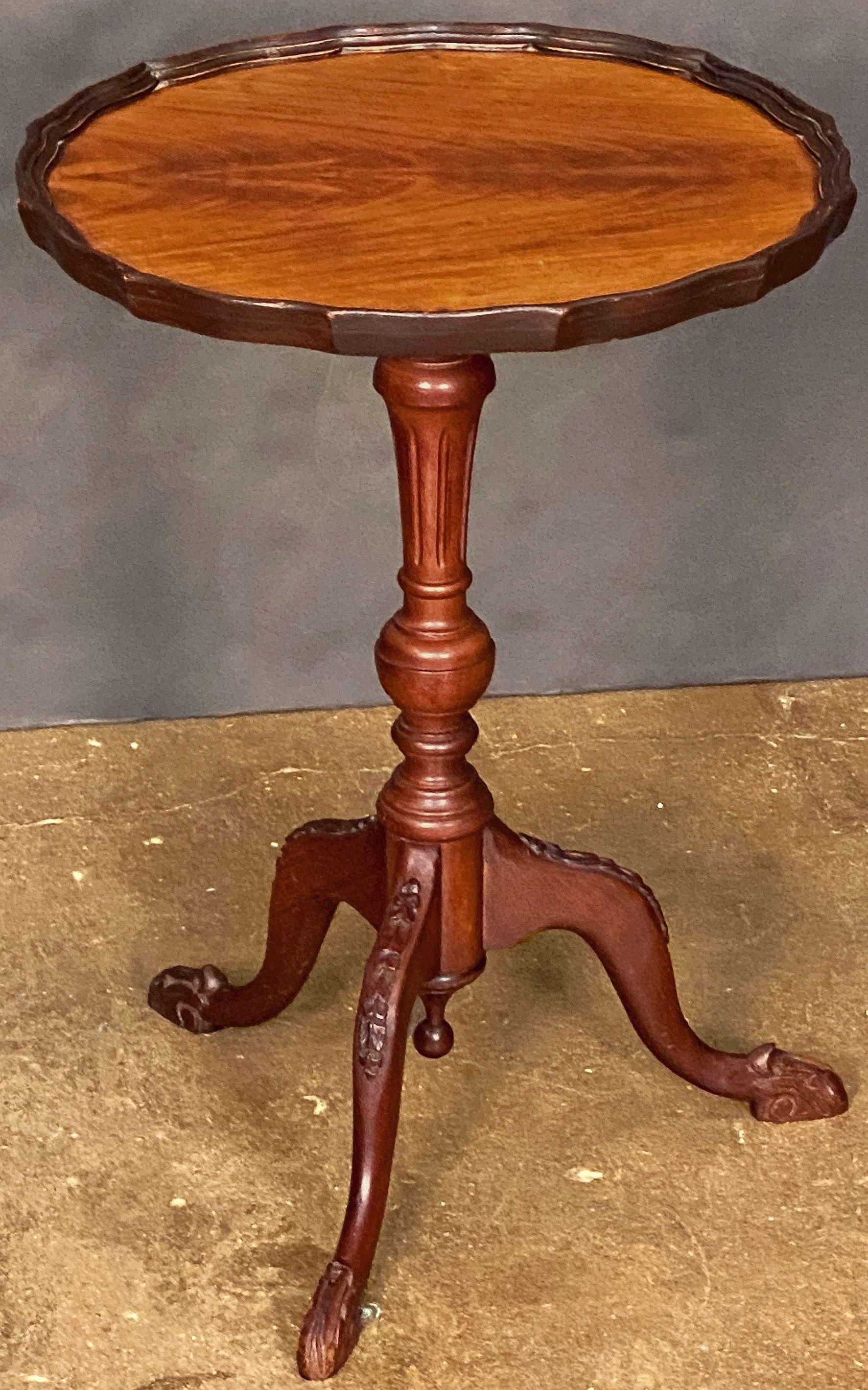 A fine English wine or cocktail table of flame walnut, featuring a raised scalloped edge (or pie-crust) around the circumference of the round or circular top, mounted upon a turned column pedestal with tripod base, with reverse finial and decorative