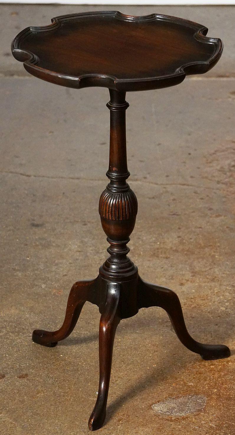An English wine table of dark walnut featuring a raised edge around the circumference of the scalloped, moulded top, mounted upon a turned column pedestal with tripod base.

An excellent choice as a side table or for serving.

Note: The table top