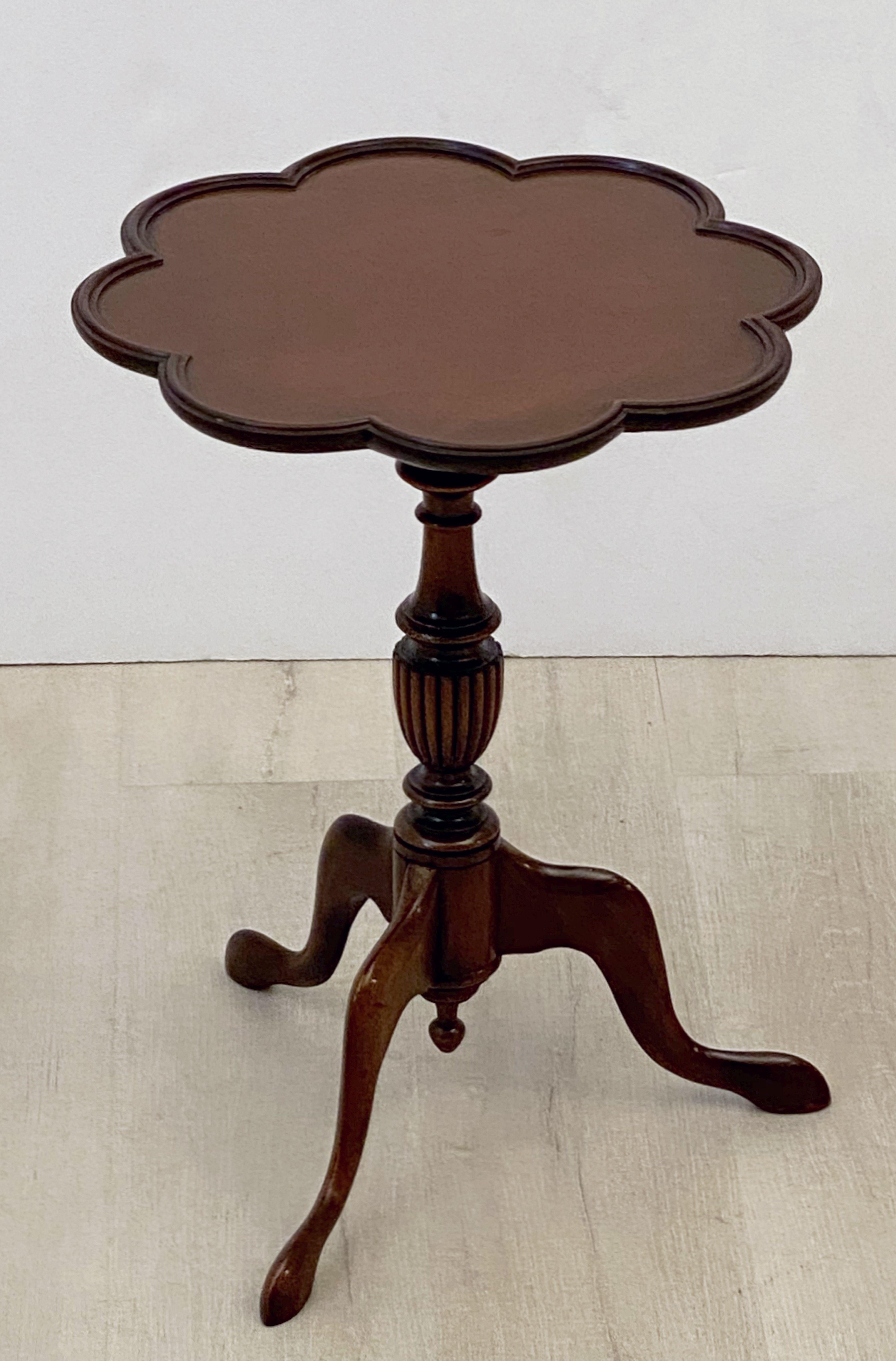 An English wine table of mahogany from the Edwardian era, featuring a raised edge around the circumference of the scalloped, moulded top, mounted upon a turned column pedestal with tripod base.

An excellent choice as a side table or for serving.