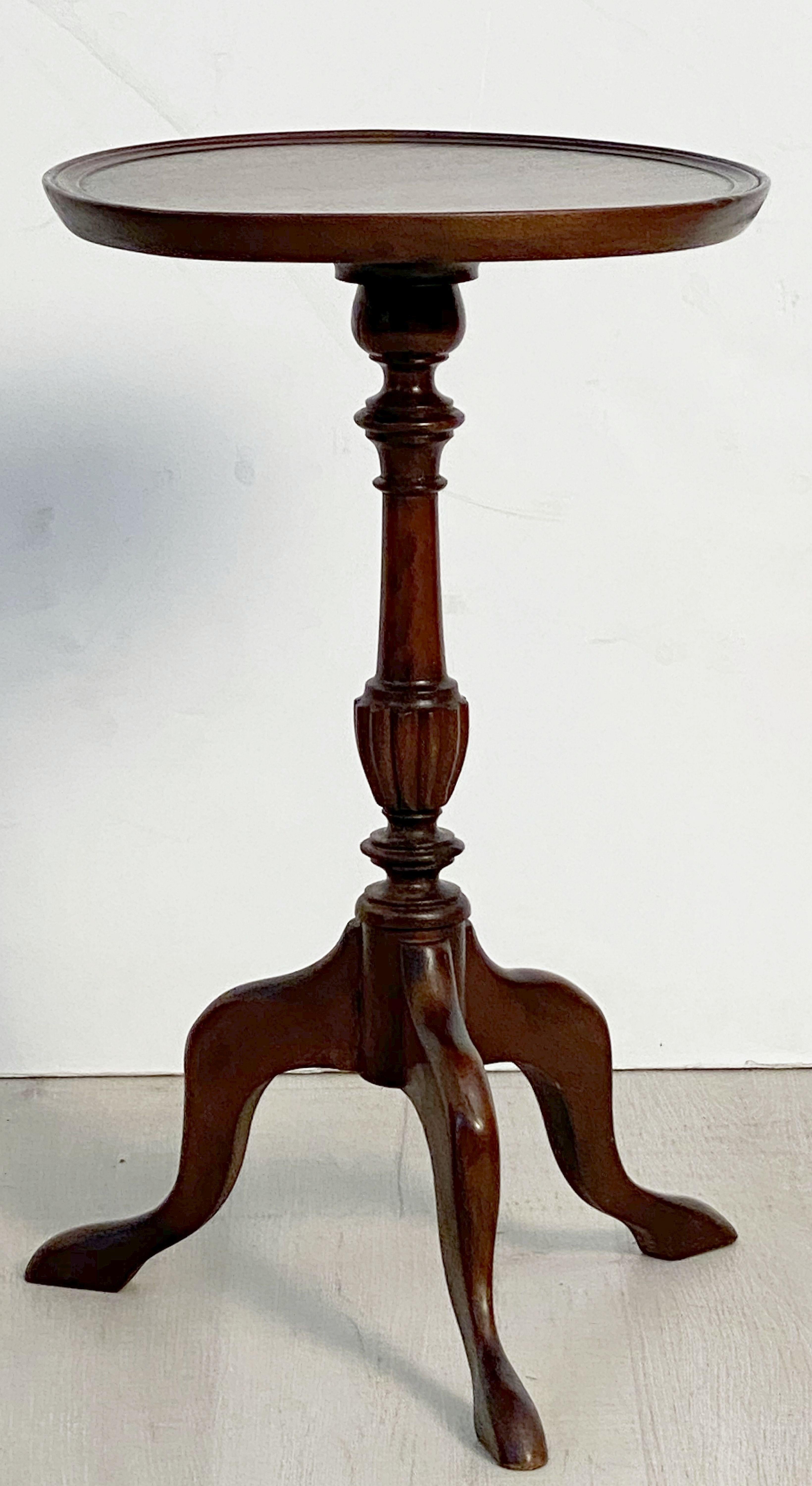An English wine table of mahogany from the Edwardian era, featuring a raised edge around the circumference of the round, moulded top, mounted upon a turned column pedestal with tripod base. 

An excellent choice as a side table or for serving.