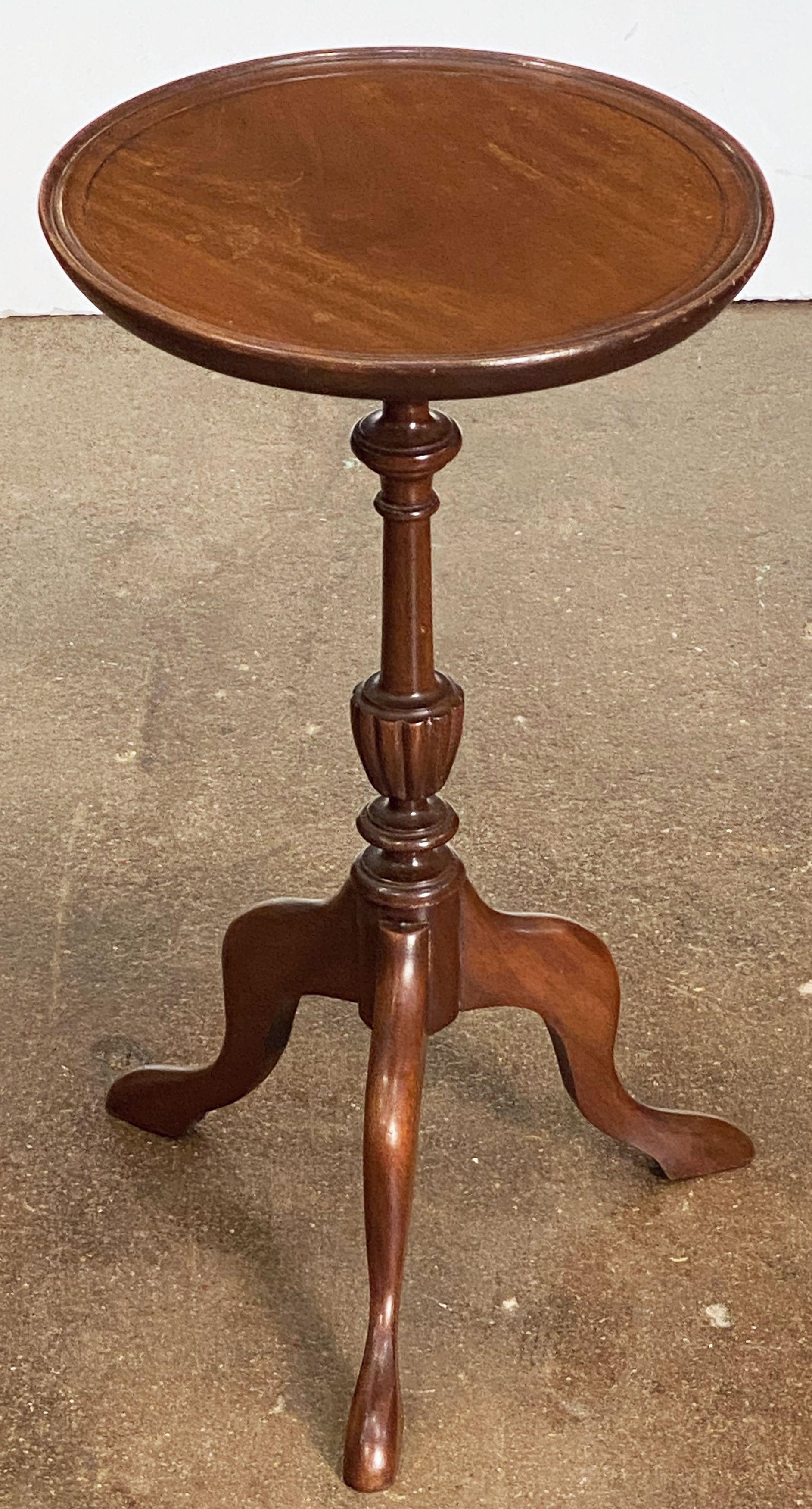 An English wine table of mahogany from the early 20th century, featuring a raised edge around the circumference of the round, moulded top, mounted upon a turned column pedestal with tripod base.

An excellent choice as a side table or for