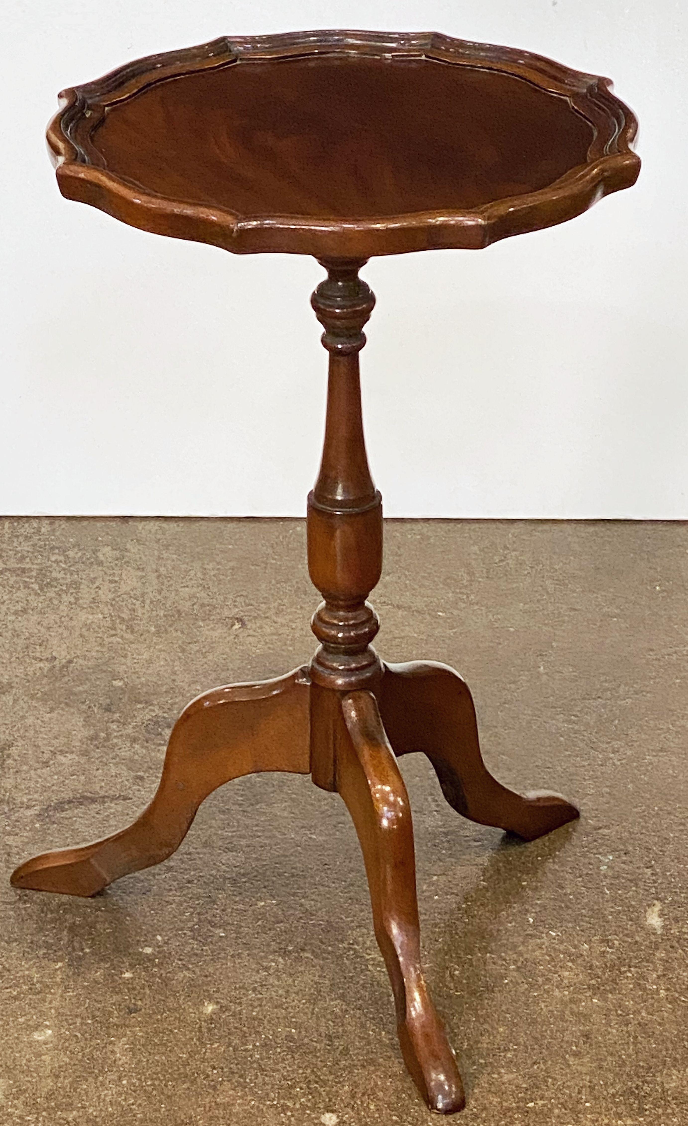 An English wine table of mahogany, featuring a raised edge around the circumference of the scalloped, moulded top, mounted upon a turned column pedestal with tripod base.

An excellent choice as a side table or for serving.