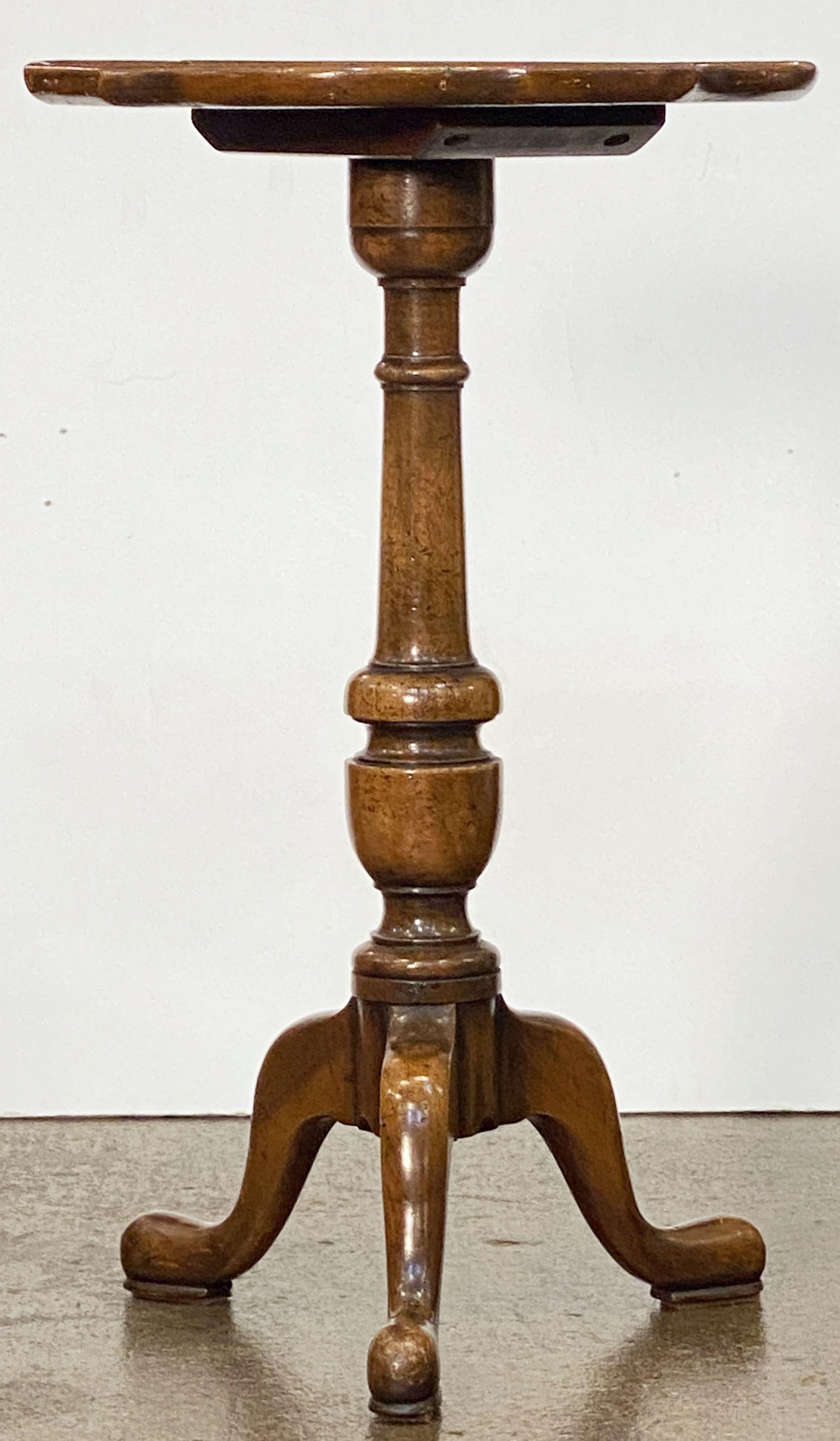 An English wine table of walnut featuring a raised edge around the circumference of the scalloped, moulded burr walnut top, mounted upon a turned column pedestal with tripod base.

An excellent choice as a side table or for serving.