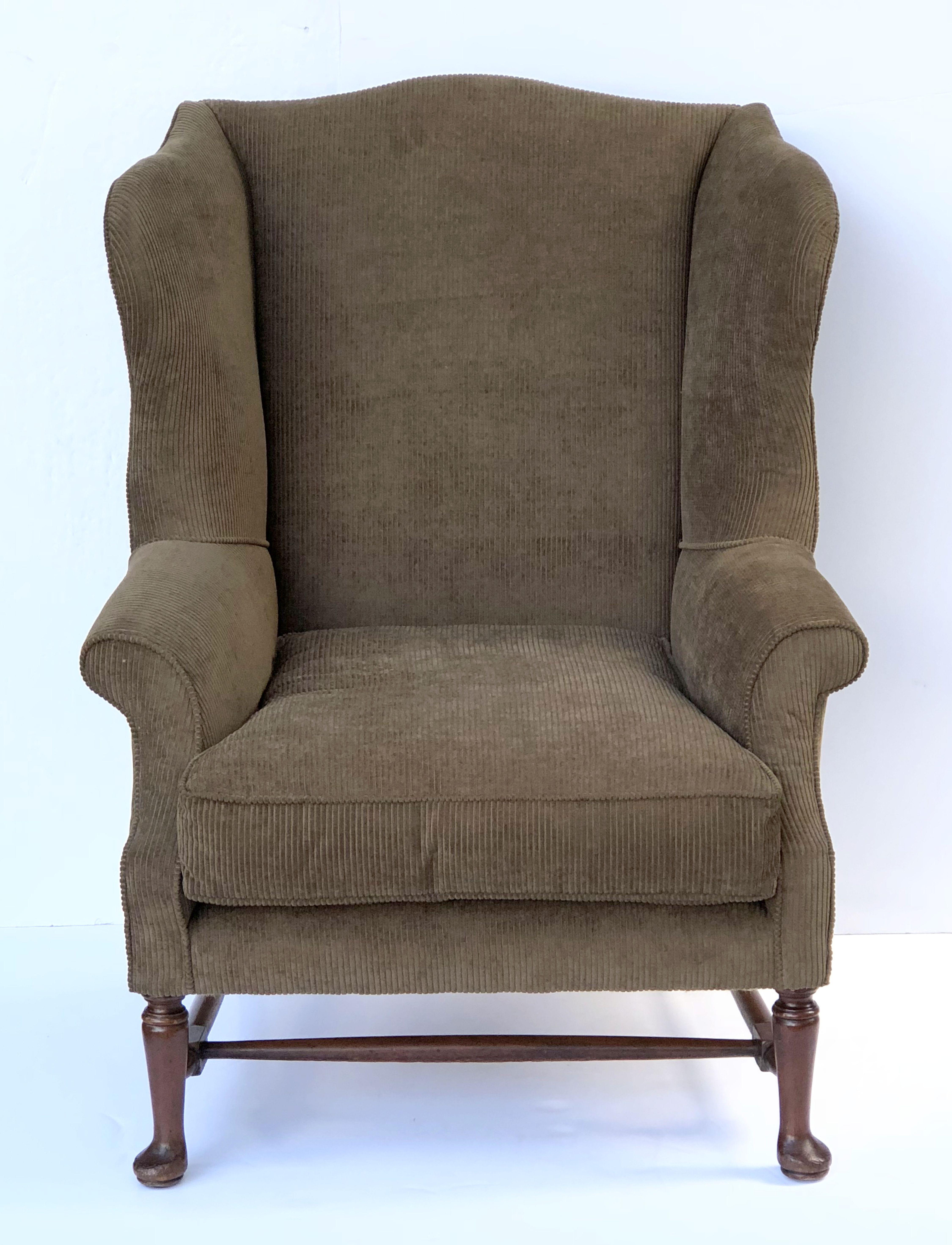 A handsome, comfortable large English wingback or fireside library chair featuring an upholstered back and arms, with pillow seat, on a turned wood stretcher.

Measures: Seat H 18 inches.