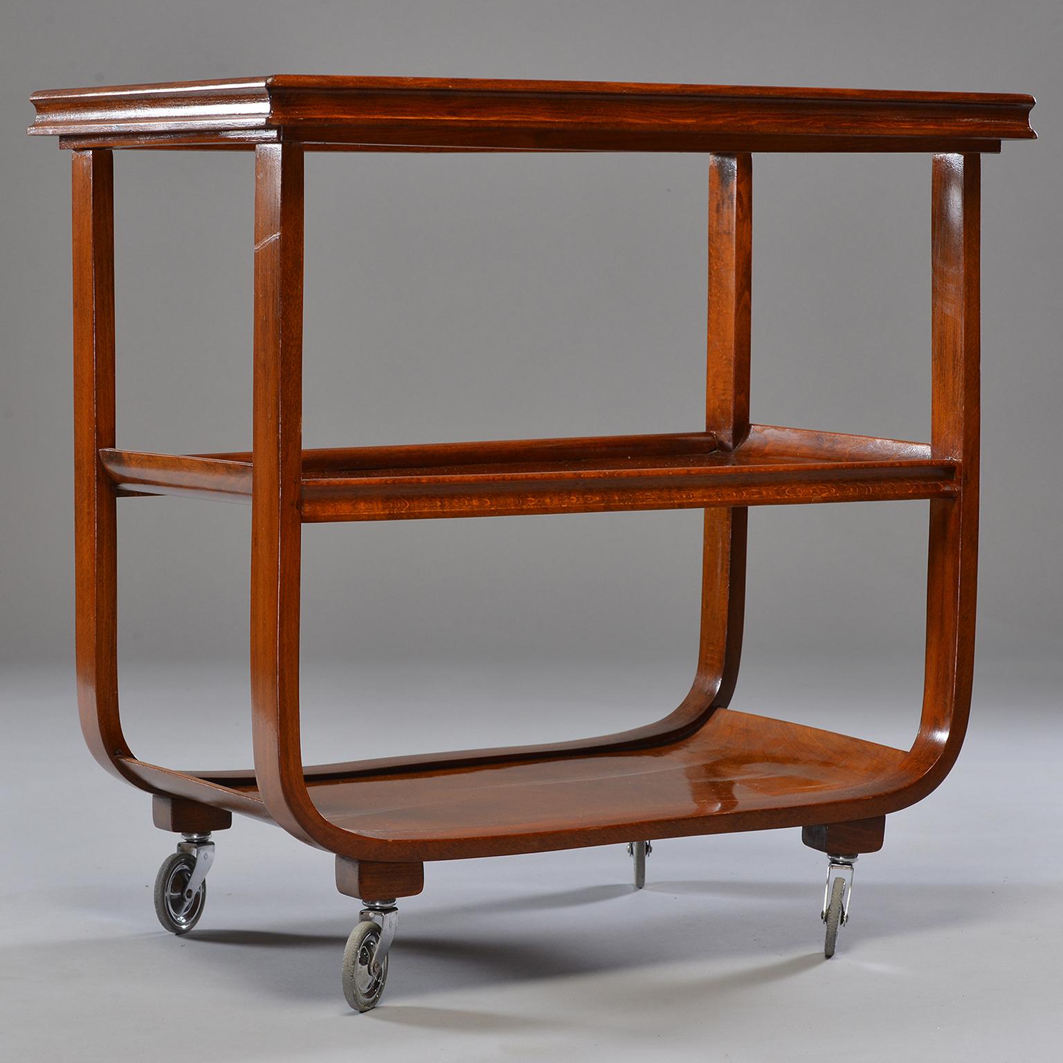 Bar or tea trolley made of dark stained wood with removable, glass-covered top tray. Found in England, circa 1940s. Unknown maker.