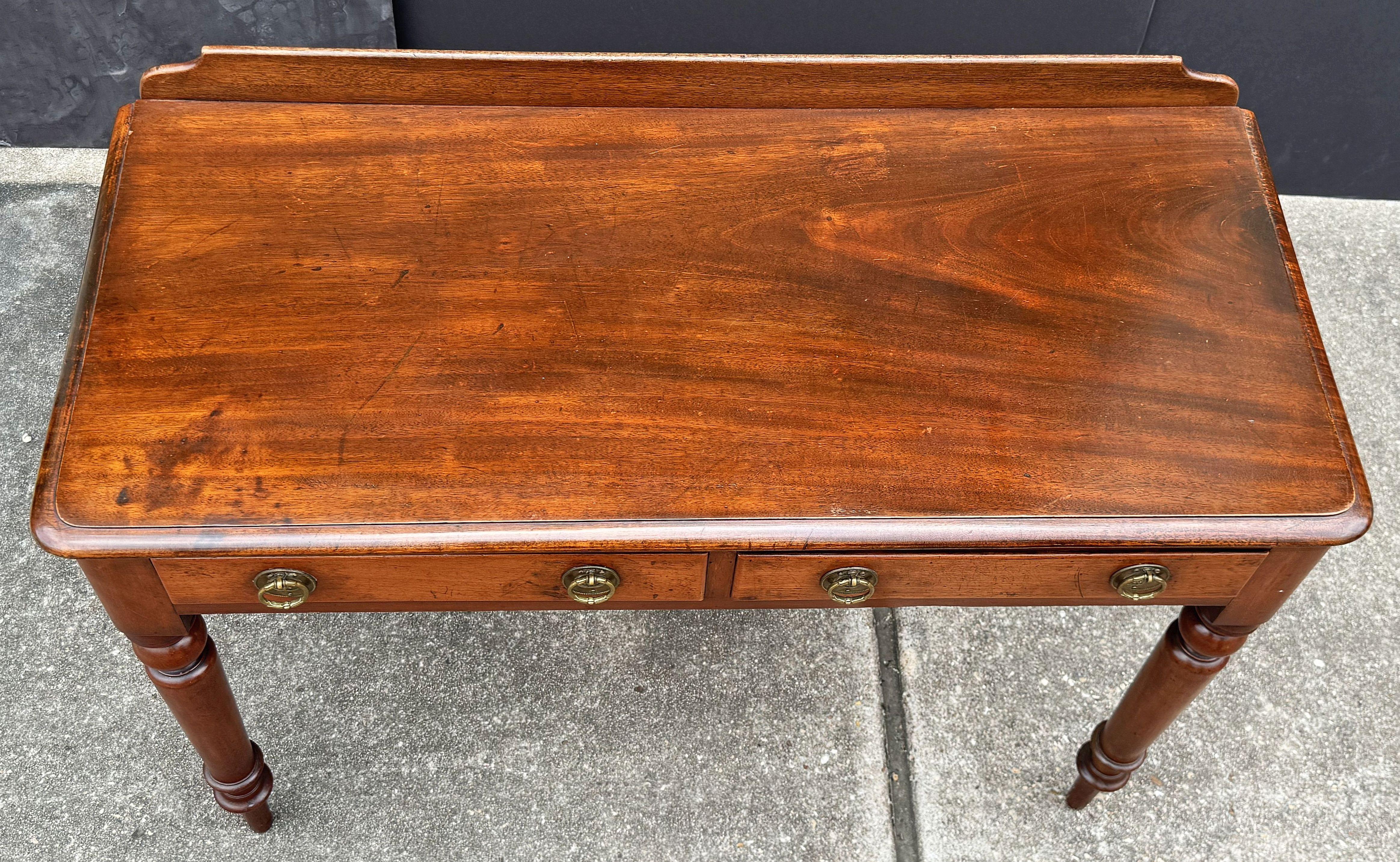 Mesa o escritorio inglés de caoba con dos cajones sobre patas torneadas siglo XIX