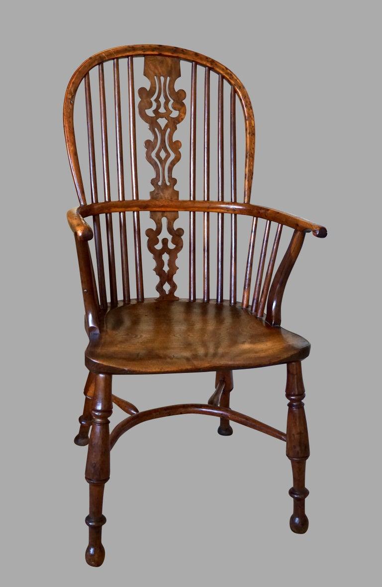 An excellent quality English yew wood narrow arm Windsor chair, the elaborate wavy pierced back splat over an elm saddle seat, supported on turned legs connected with crinoline stretcher. Lovely honey color with good patina. The back splat is