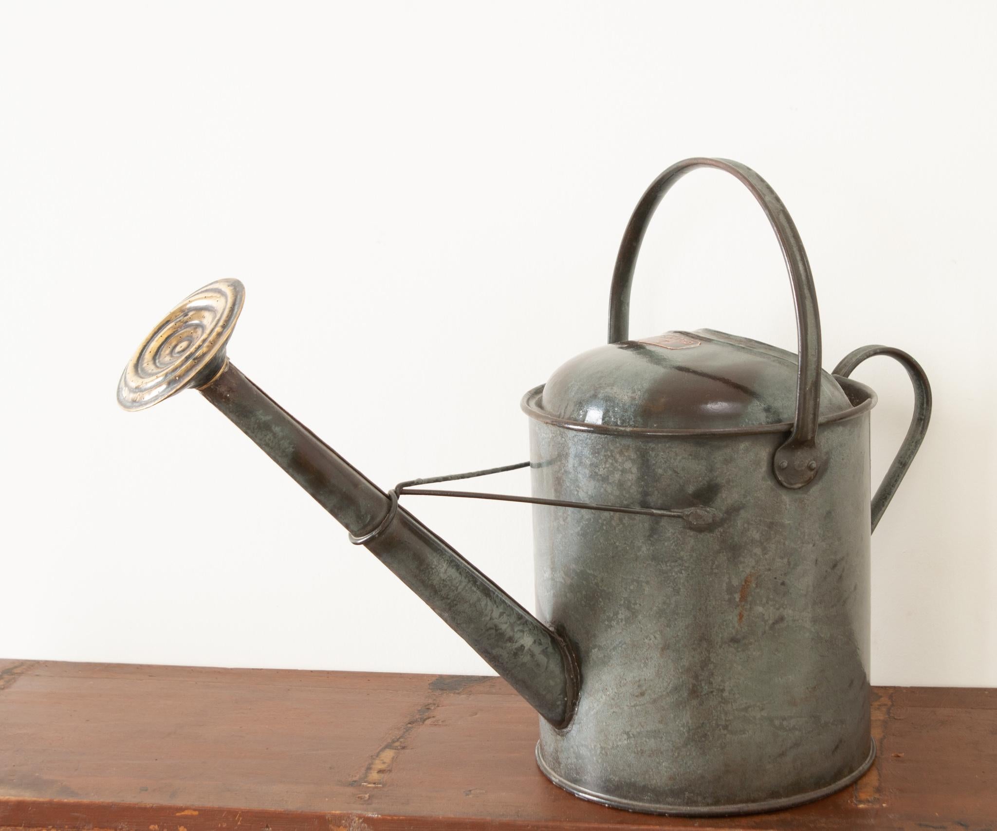 This whimsical English garden antique is just as functional as it is decorative. Crafted from zinc with accents of brass- the whole has gained a great patina. Double handles; one for carrying, the other for pouring- make it convenient to use daily.