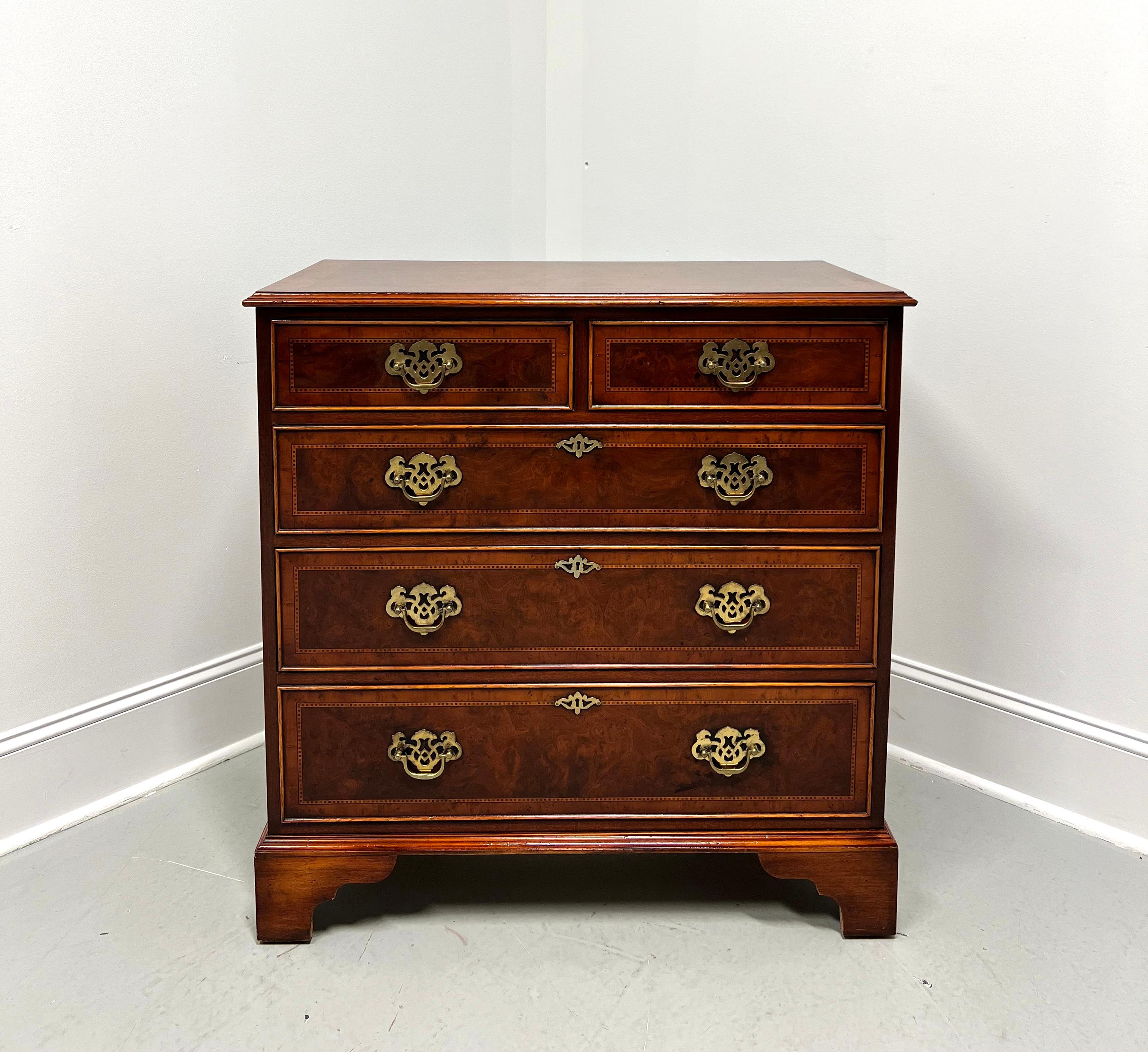 A Chippendale style bachelor chest by Englishman's. Burl elm with a distressed finish, banded & inlaid top with a bevel edge, decorative brass hardware, faux keyhole escutcheons, banded & inlaid drawer fronts, and bracket feet. Features two smaller