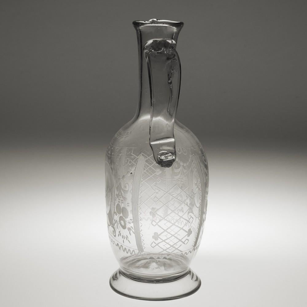 Engraved 18th century Claret Jug, circa 1780

Additional Information:
Date: circa 1780
Origin: Probably Germany or Bohemia
Colour: Clear
Neck: Tapered with sparrow beak lip. Applied top down handle with scrolled finish
Body: Engraved with