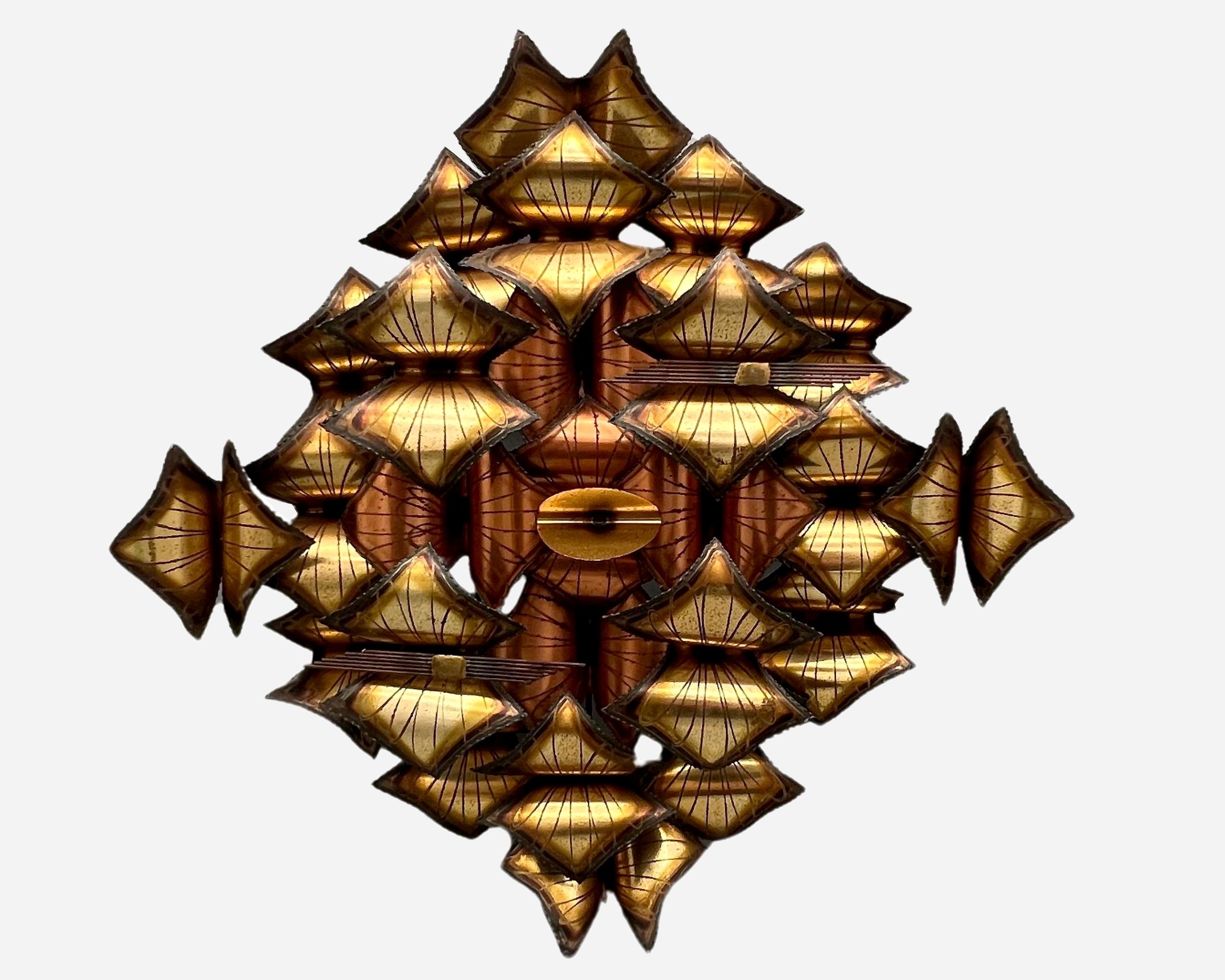 Scultura appesa al muro composta da forme di rame rosso e ottone tagliate alla fiamma, incise e saldate su una struttura in ferro leggero. 

Firmato ma firma indecifrabile. Nello spirito di Curtis Jeré.