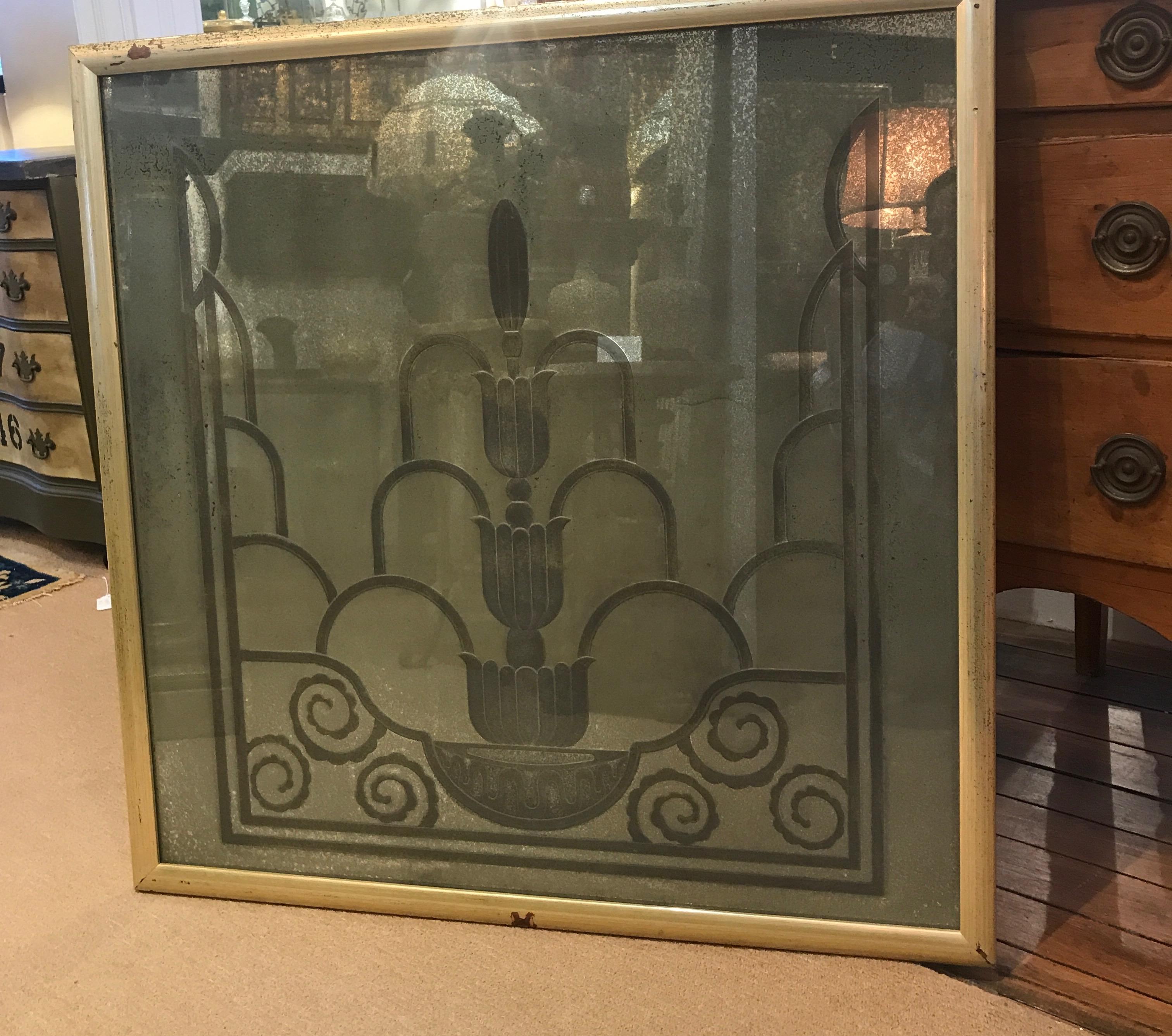 Fabulous engraved mirror from the Art Deco period from the Waldorf Astoria in NYC. Classic late 1920s deco design of a stylized fountain engraved on the back of the silvered glass in a later silver gilt frame. The silvering is fogged and aged, the