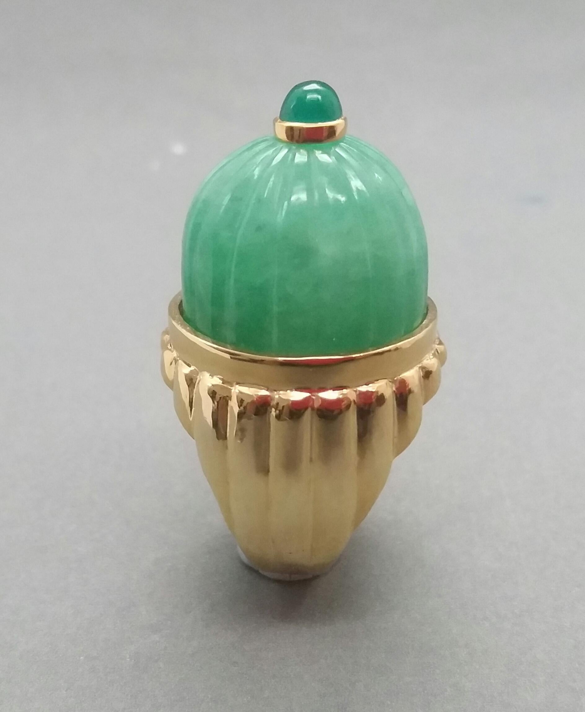 An Engraved Burma Jade Cabochon measuring 20 mm in diameter and 15 mm in hight with a Emerald 5 mm round cabochon set in yellow gold on top are mounted on a 14 kt yellow gold  engraved shank  weighing more than 9 grams.

In 1978 our workshop started