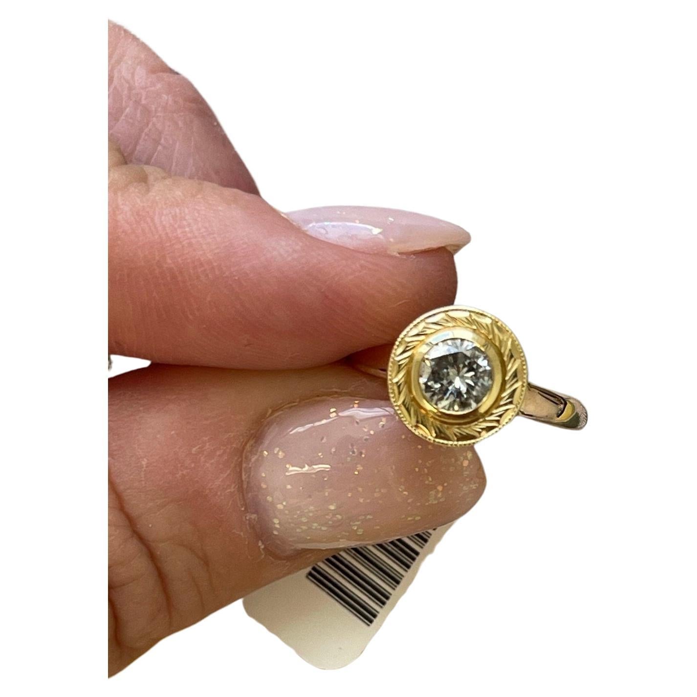 What a unique piece this is! 
Hand engraved diamond ring, this is a very tedious process and only very few masters know how to do it. This ring can take several hours of engraving on gold. Made with so many little details in a unique bezel setting
