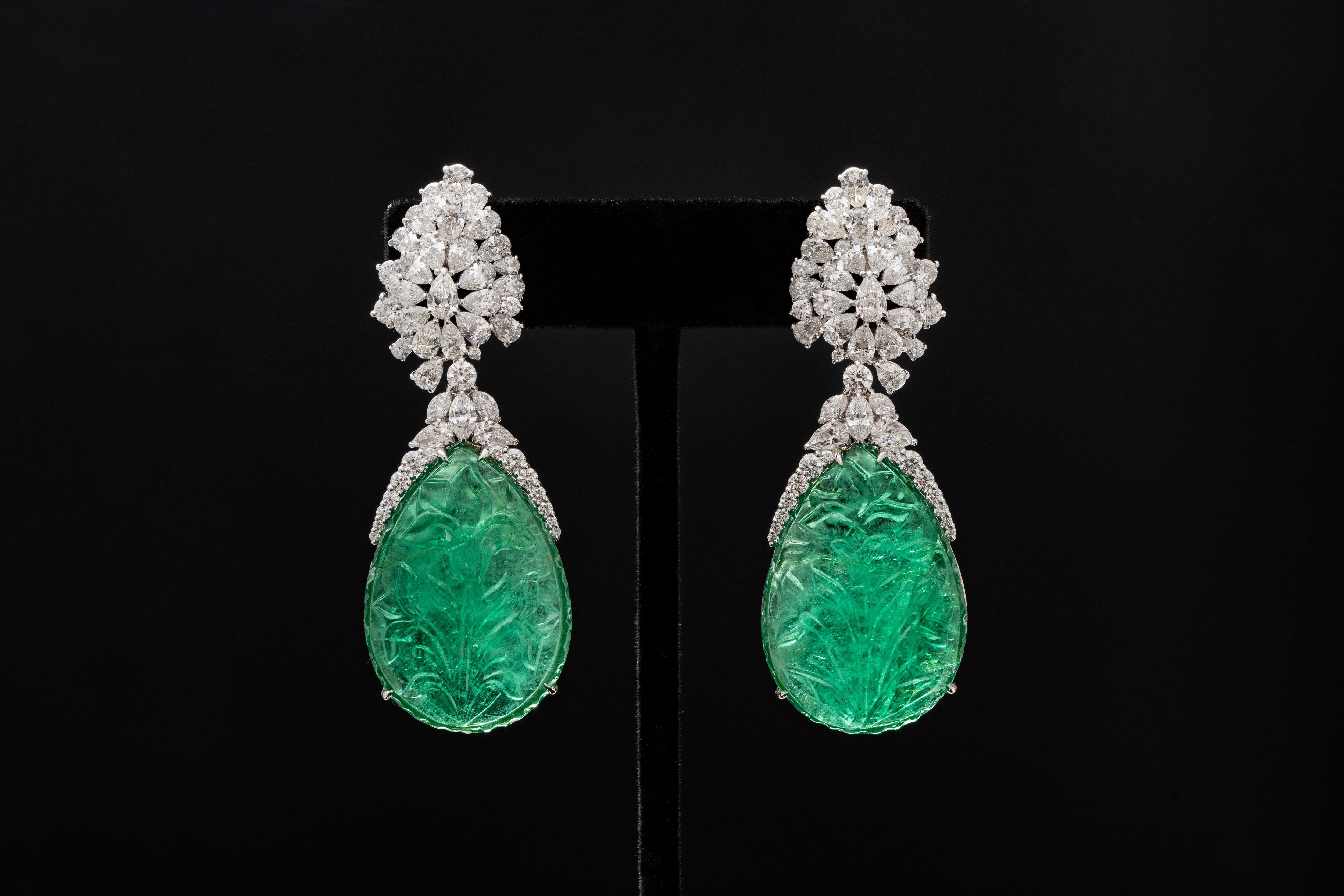 Set with a perfect pair of pear-shaped one carved Emeralds, weighing 58.34ct and 53.94ct respectively, mounted in18K, hanging with all pear shape daimond 
Size of 53.94ct: 35.86x25.53x8.20 mm
Size of 58.34ct: 35.91x25.30x8.77 mm
