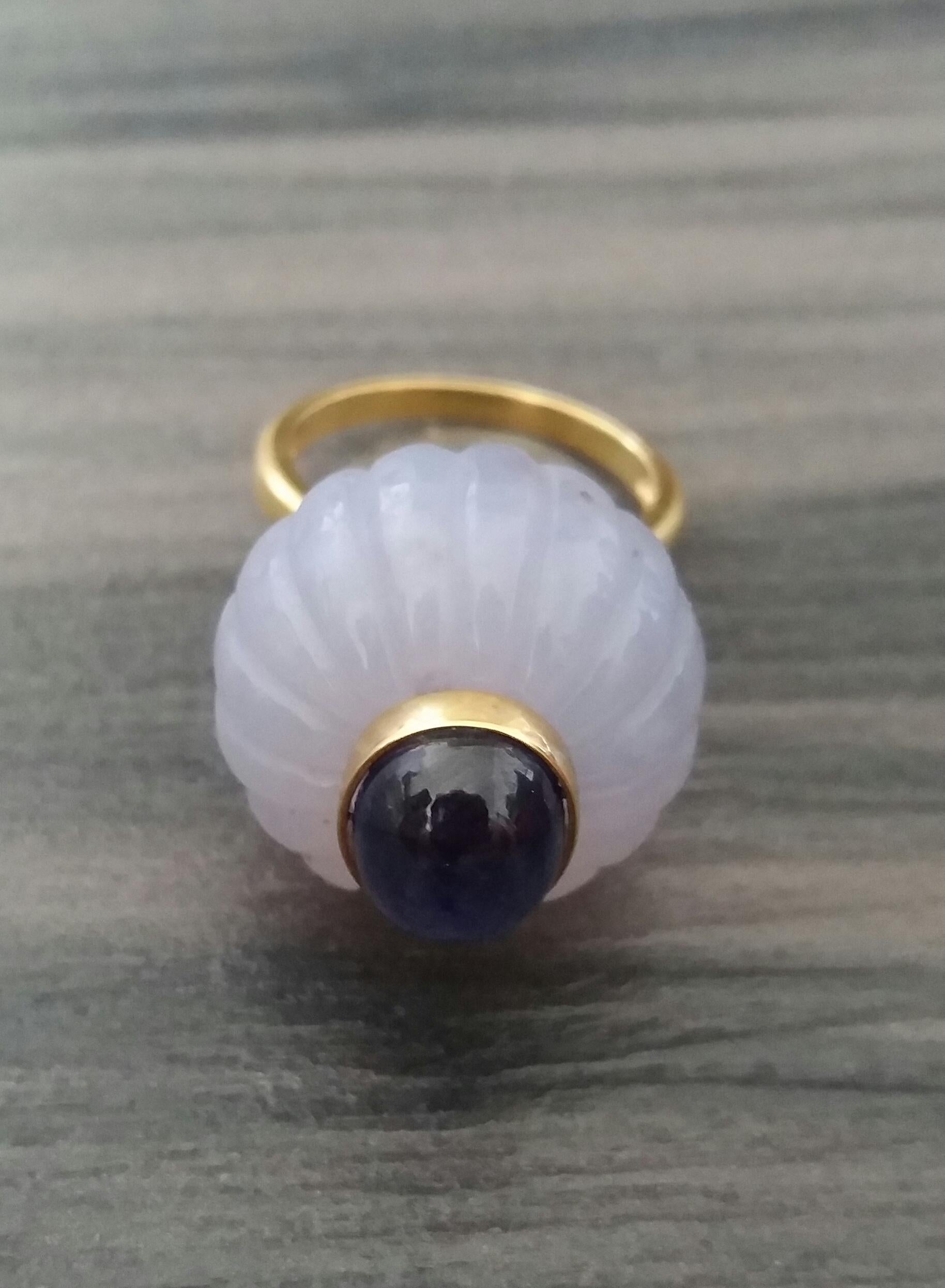 
Melon cut Chalcedony Round Bead of 20 mm. in diameter and 16 mm. thick with in the center an Oval Blue Sapphire cabochon measuring  8x9 mm. set in 14 kt  Yellow Gold is mounted on top of a 14 Kt. white gold  ring ( actual size #7, but can resize
