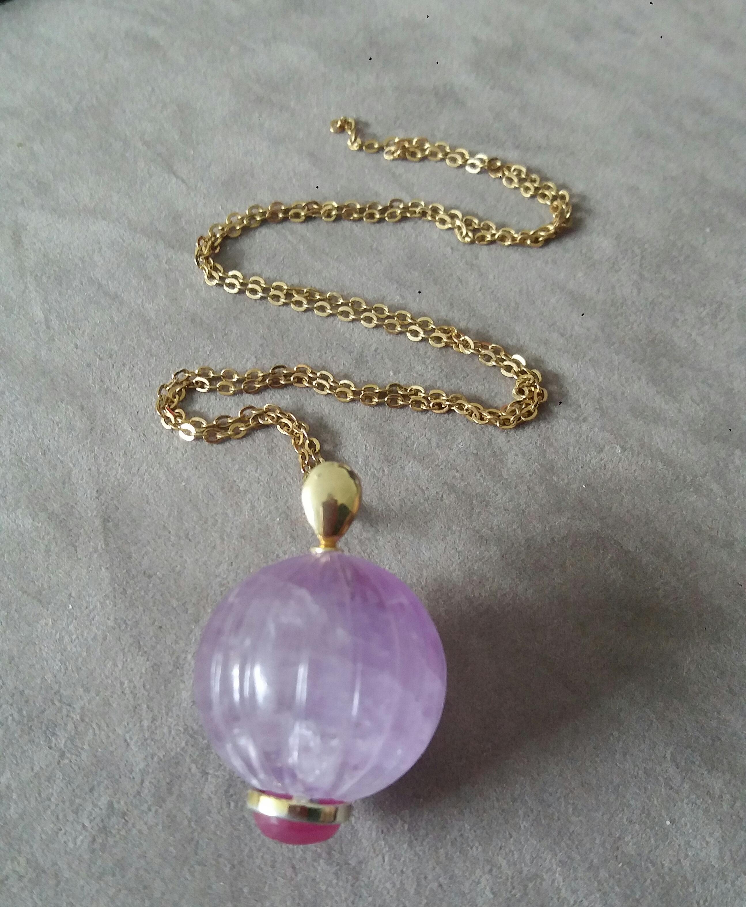 A unique pendant made of an Engraved Genuine Amethyst Round Bead 25 mm in diameter,set with an oval Ruby Cabochon measuring 8x10 mm. and a yellow gold pendant bail on the top part.

In 1978 our workshop started in Italy to make simple-chic Art Deco