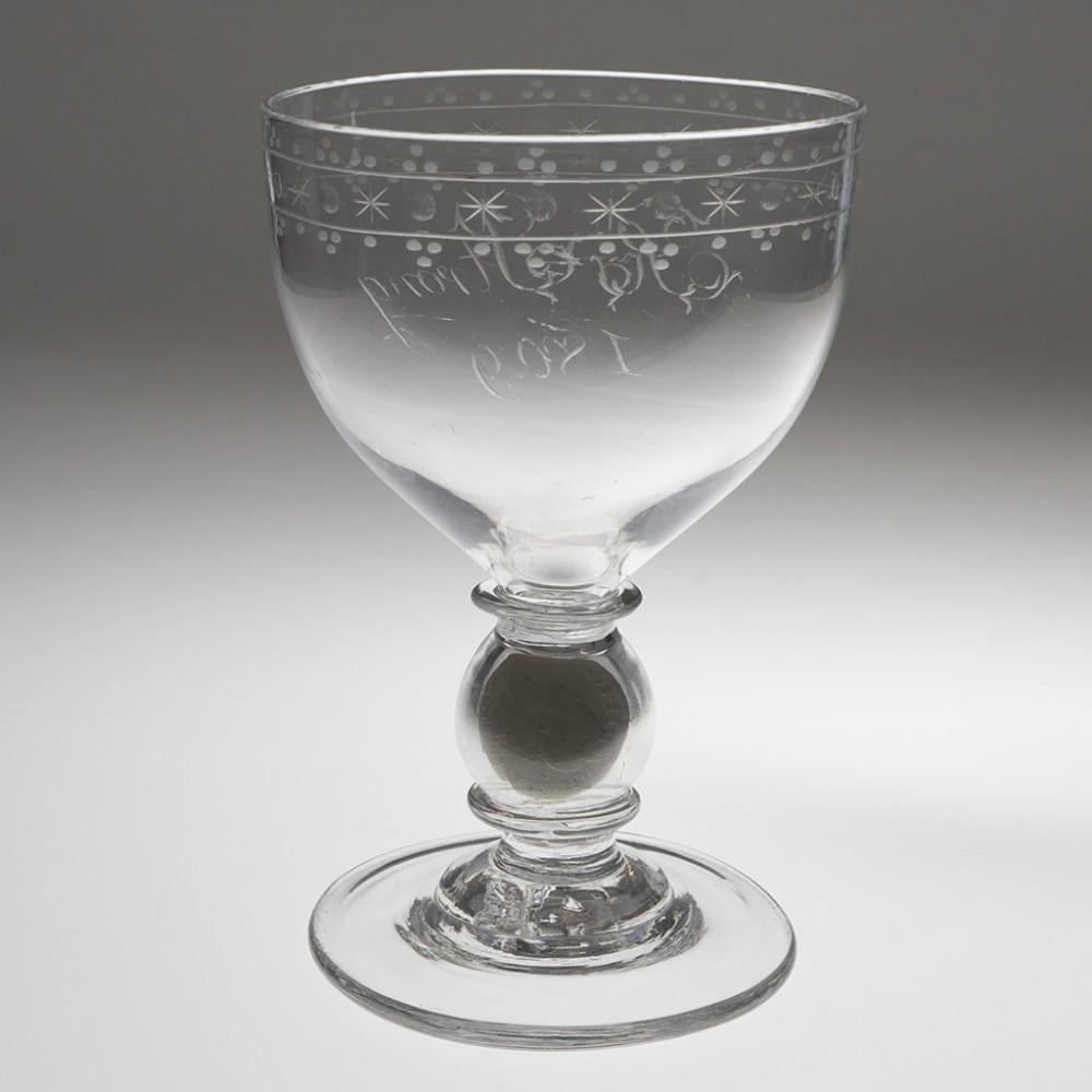 Heading : Engraved Georgian coin goblet
Period : George III/Regency - c1800-1820
Origin : England
Colour : Clear
Bowl : Round funnel, engraved with an OXO band bordered by pendants. Dated 1809.
Stem : Large ball knop between an annular collar and