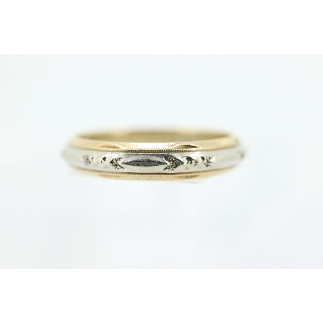 Vintage from the 1940s
Size: 11 US
Materials: Gold, Rose gold, White gold
Band Color: Gold

Style: Avant-garde

Unique Wedding band or stackable ring. Multi-tone with yellow and white 14k Gold. The ring is engraved with a repeated Flower design.